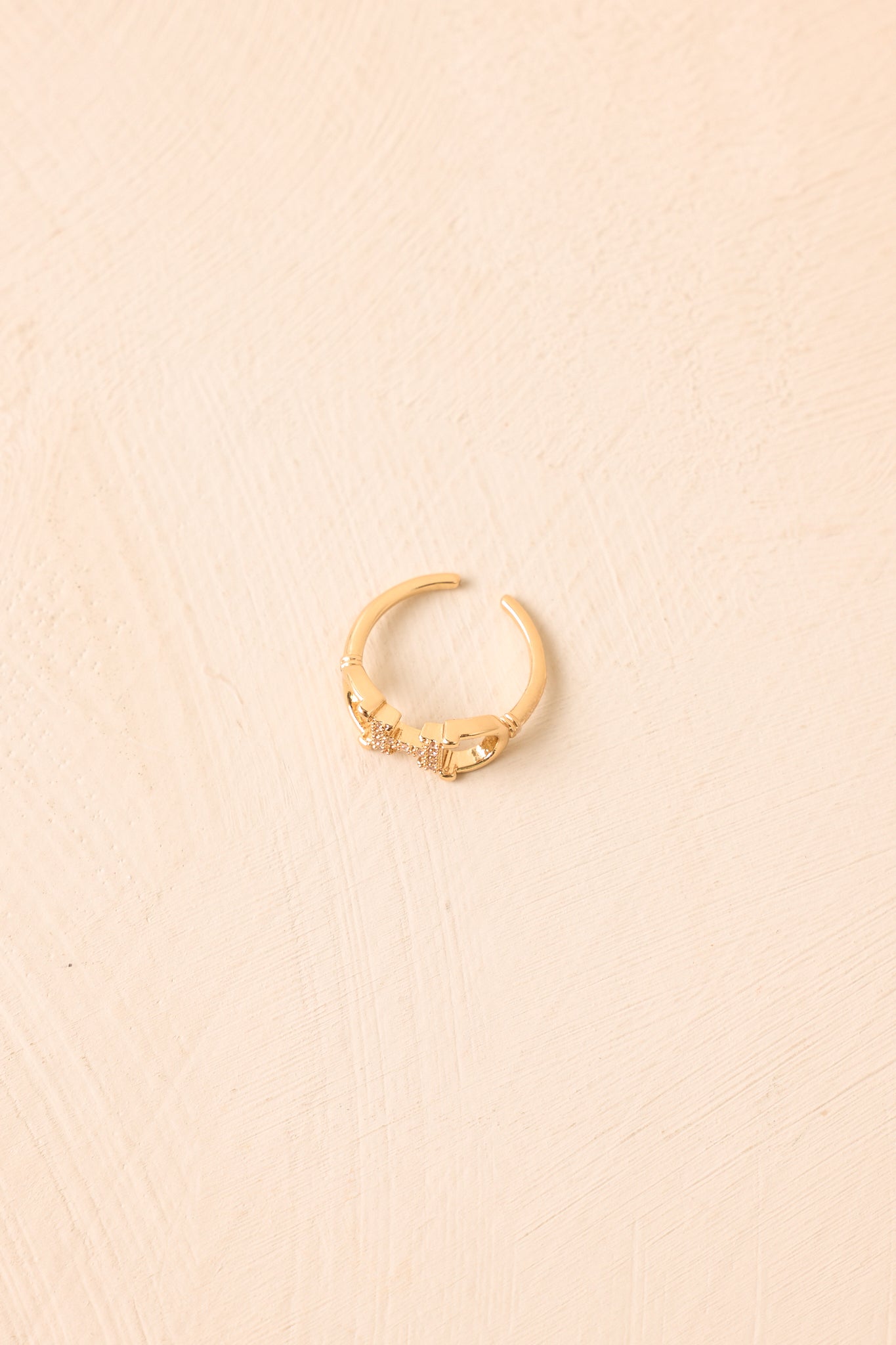 Close-up of the gold-tone adjustable ring showcasing the sculptural horsebit centerpiece, delicate crystal accents, and polished open band.