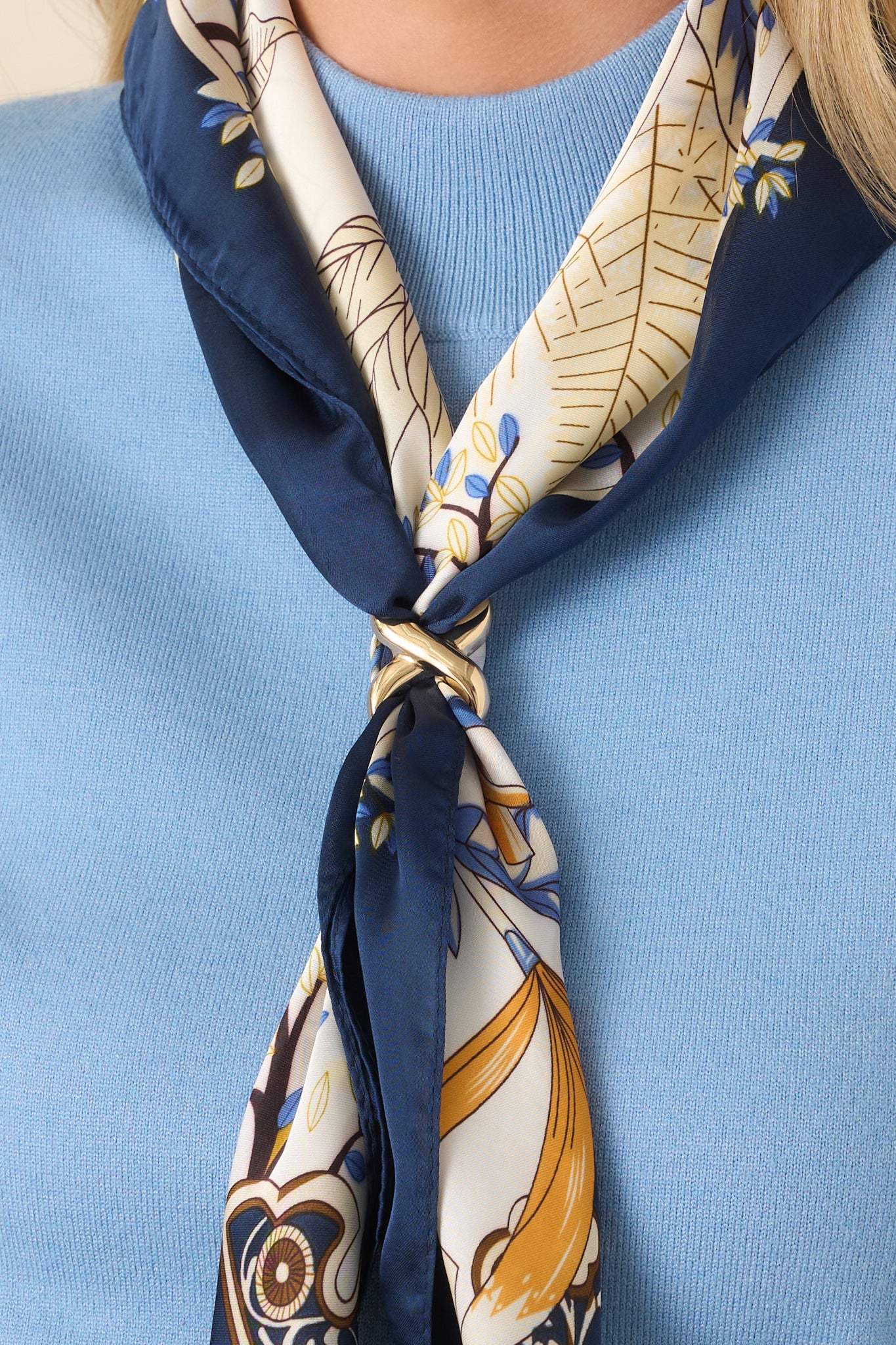 Polished gold-tone scarf ring featuring a smooth, sculptural silhouette and elegant crisscross design.