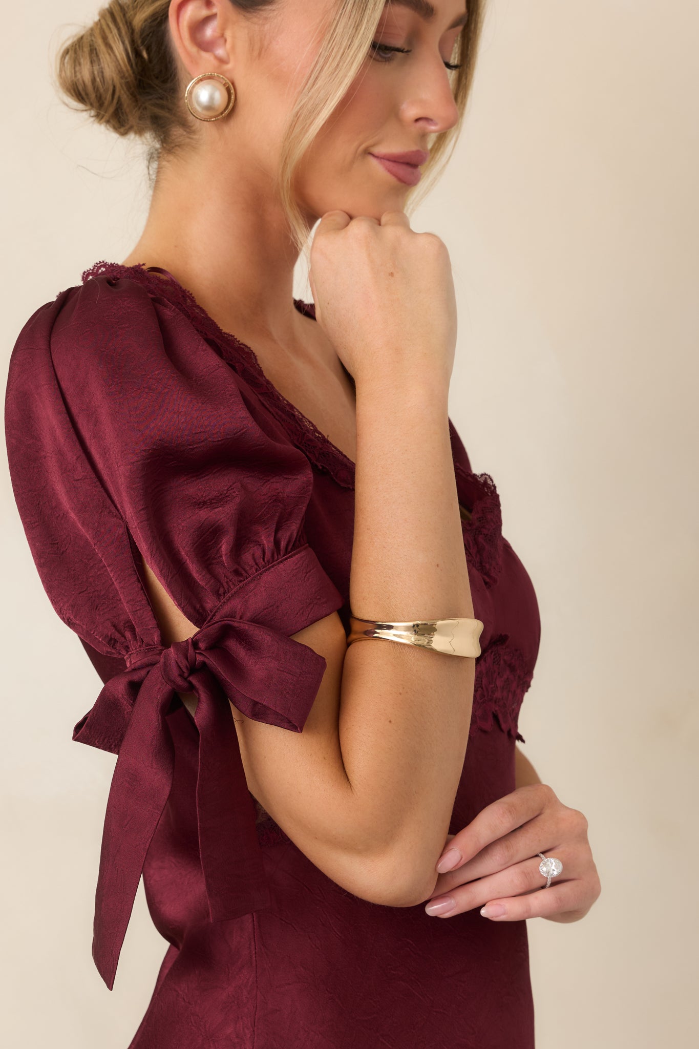 Sculptural gold-tone bangle featuring a gently concave silhouette with alternating wide and narrow sections.