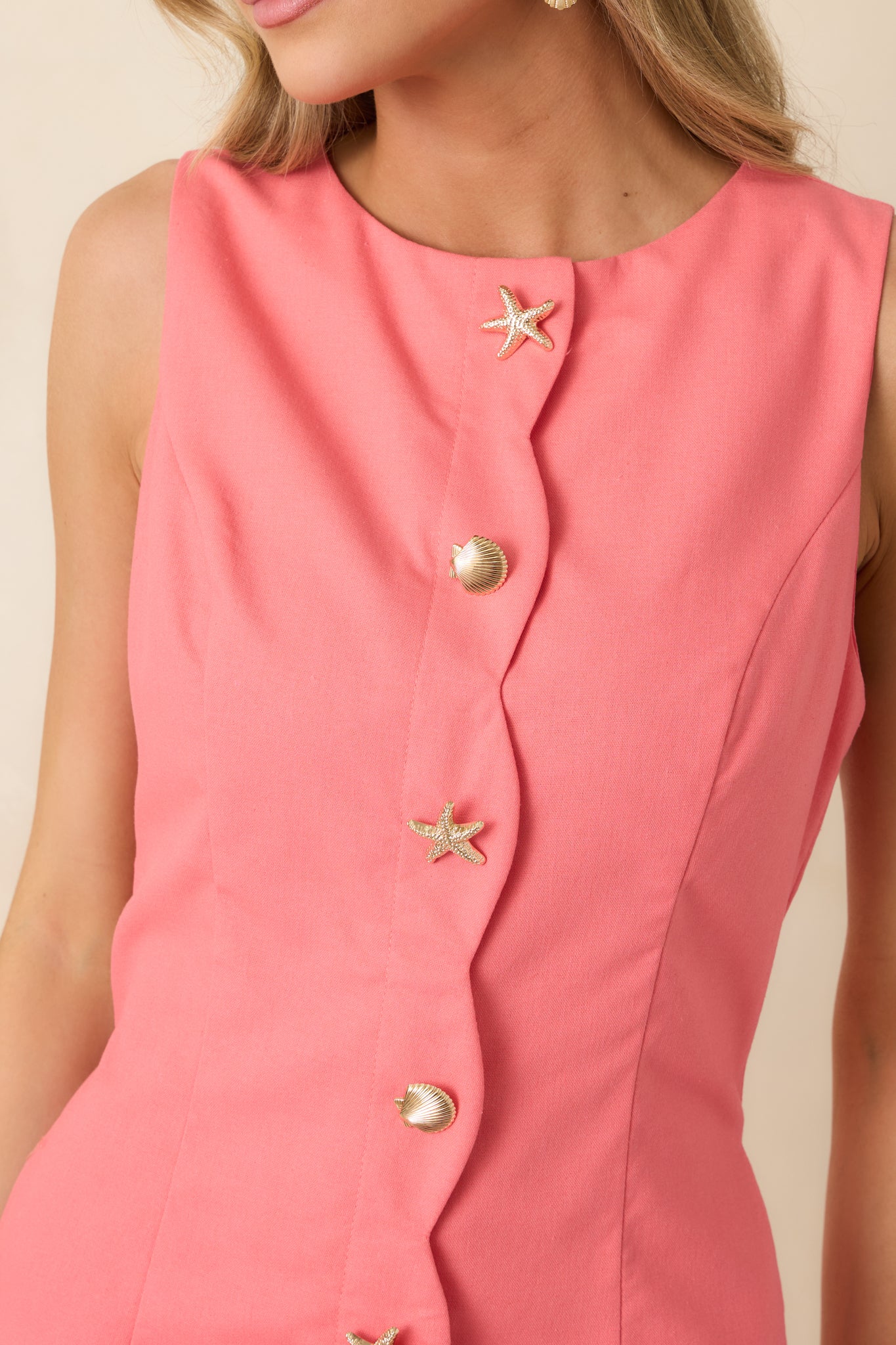 Gold-tone starfish and shell buttons with scalloped edge detail on coral fabric