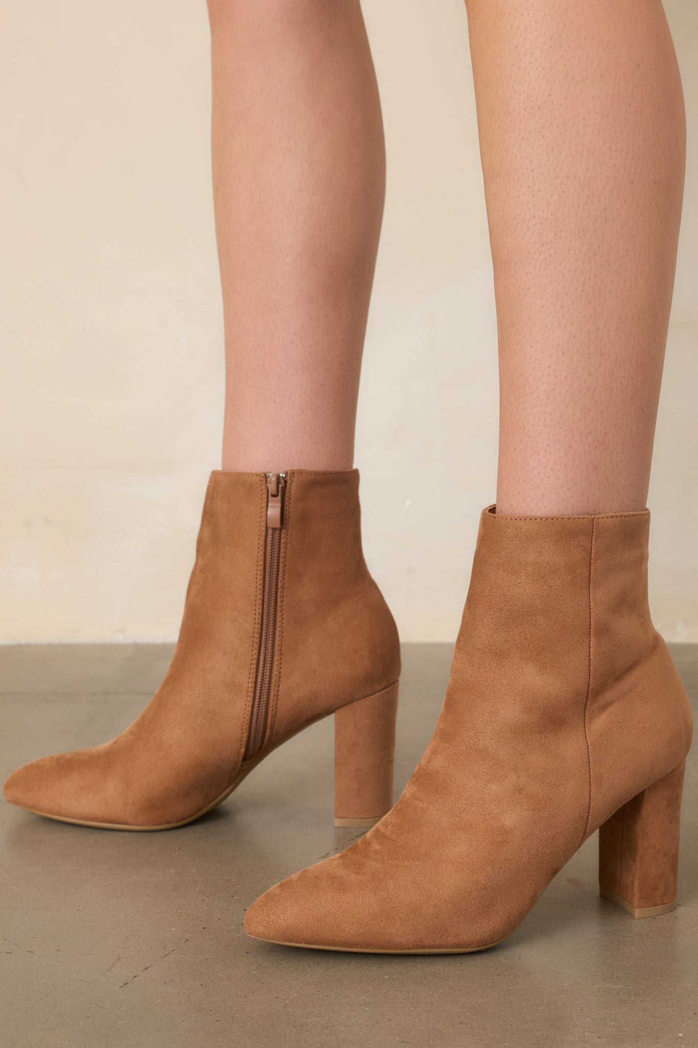 Golden brown ankle boots featuring a smooth faux suede exterior, defined side seams, and a distinctive stacked block heel.