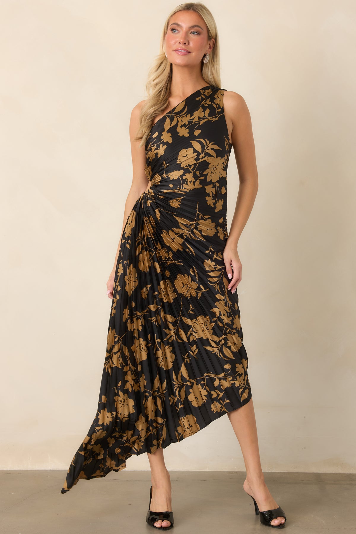 Golden florals decorate the black satin silhouette, finished with a ruched waist, cutout detail, and high-low hem.