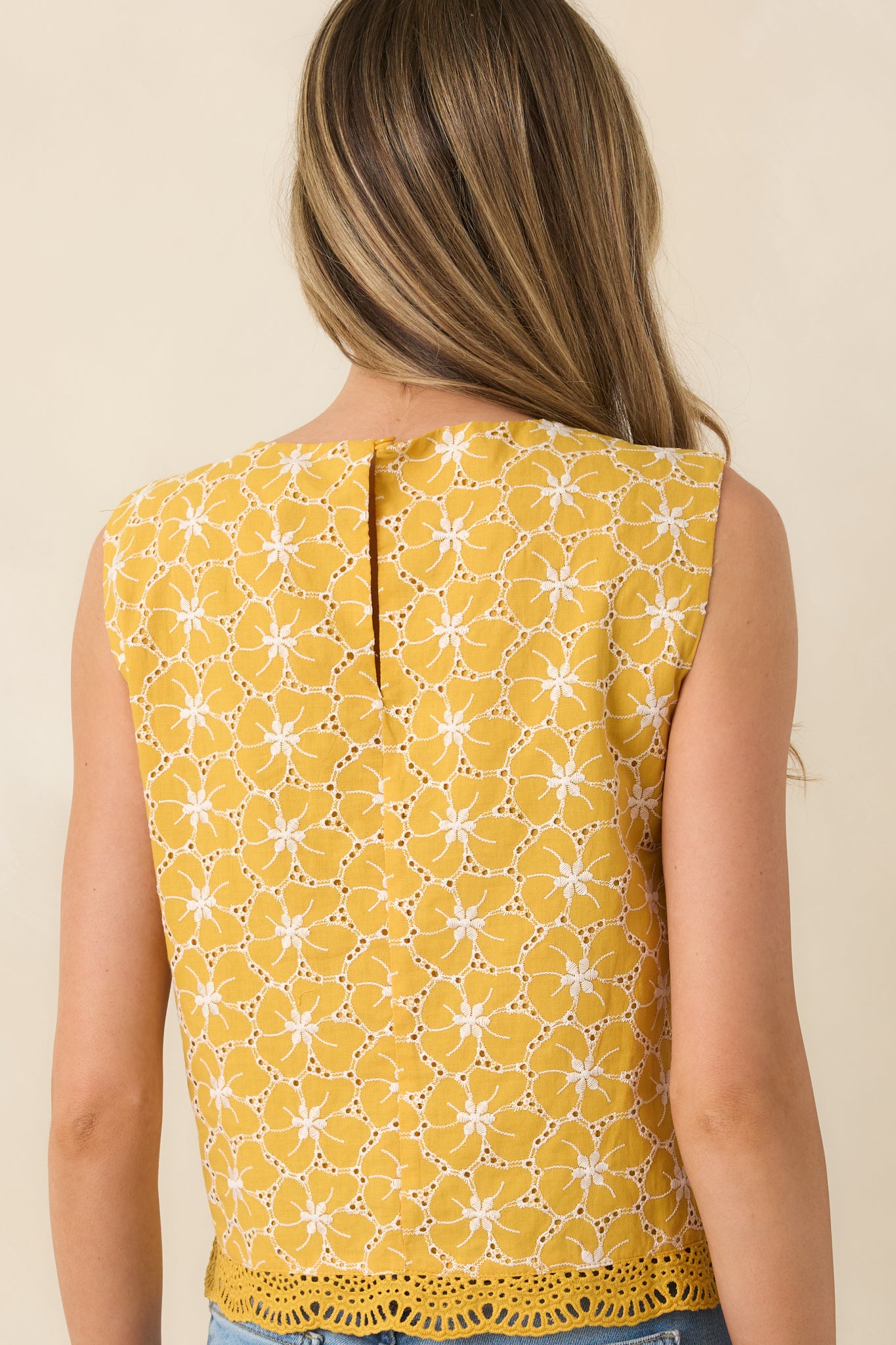 Goldenrod embroidered top with sleeveless silhouette from rear.