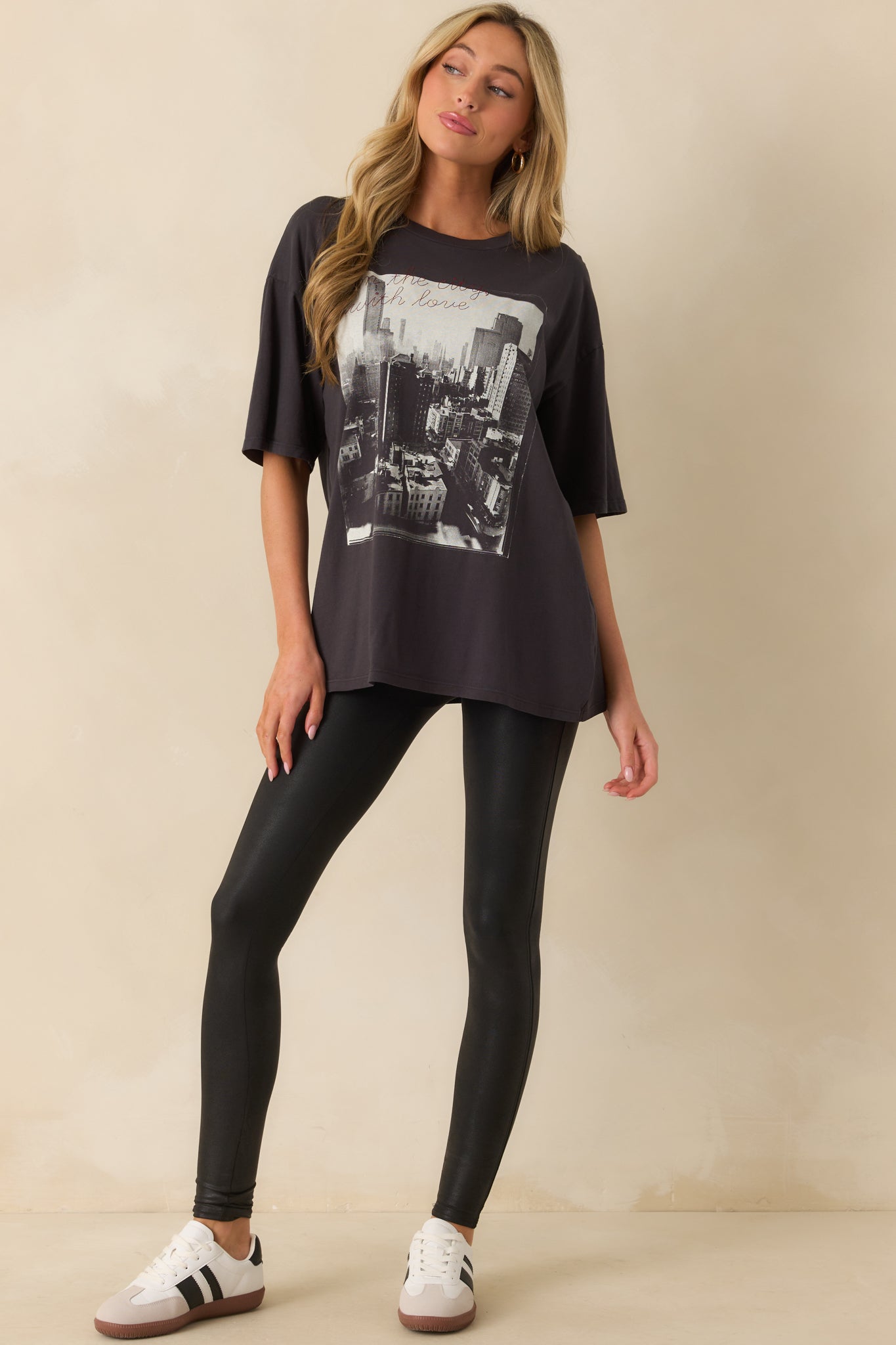 Graphic black tee featuring an urban city design with contrasting red script on the chest.