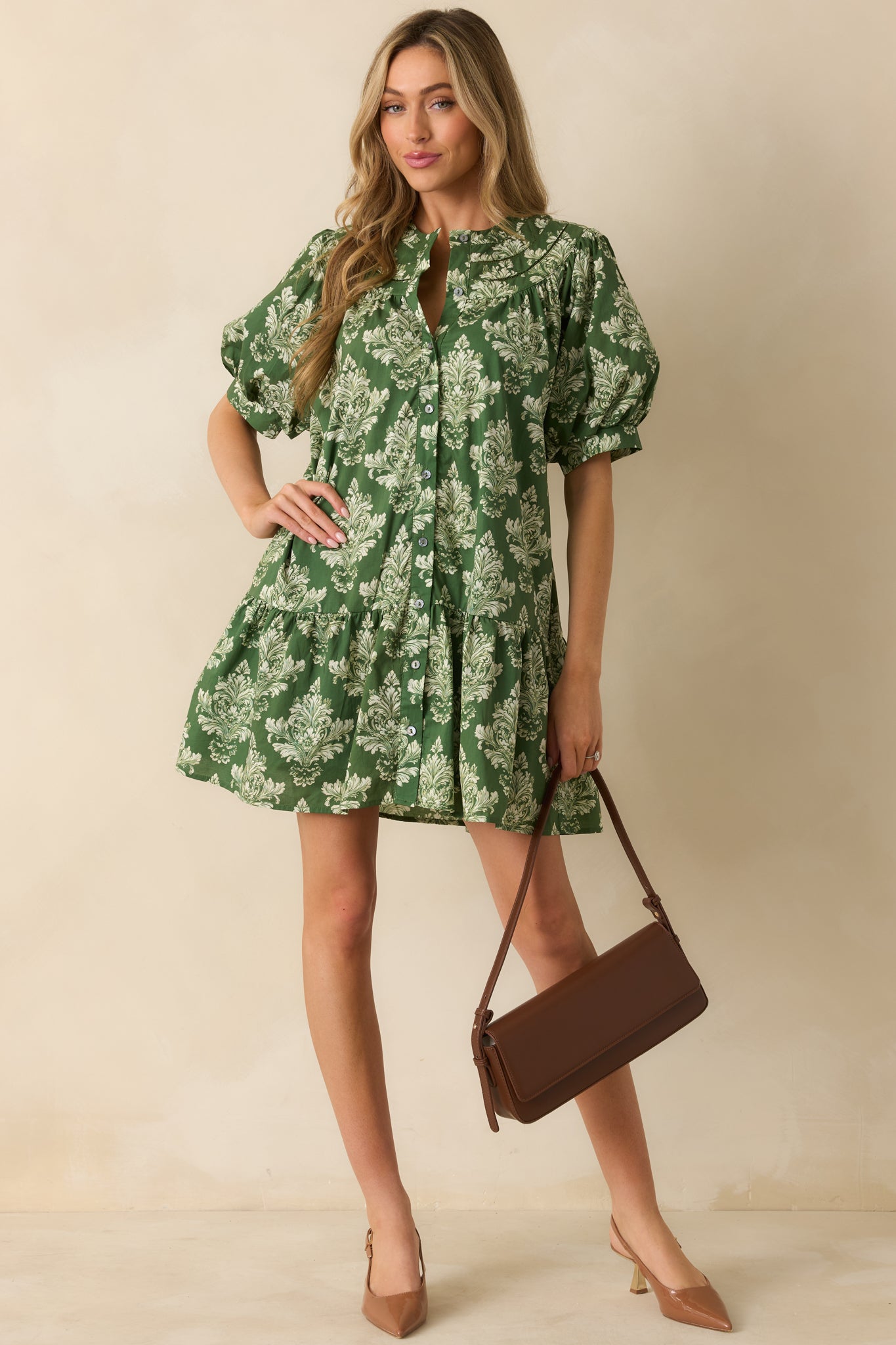 Green and ivory damask print mini dress with Peter Pan collar, button-down front, and short puff sleeves with elastic cuffs.