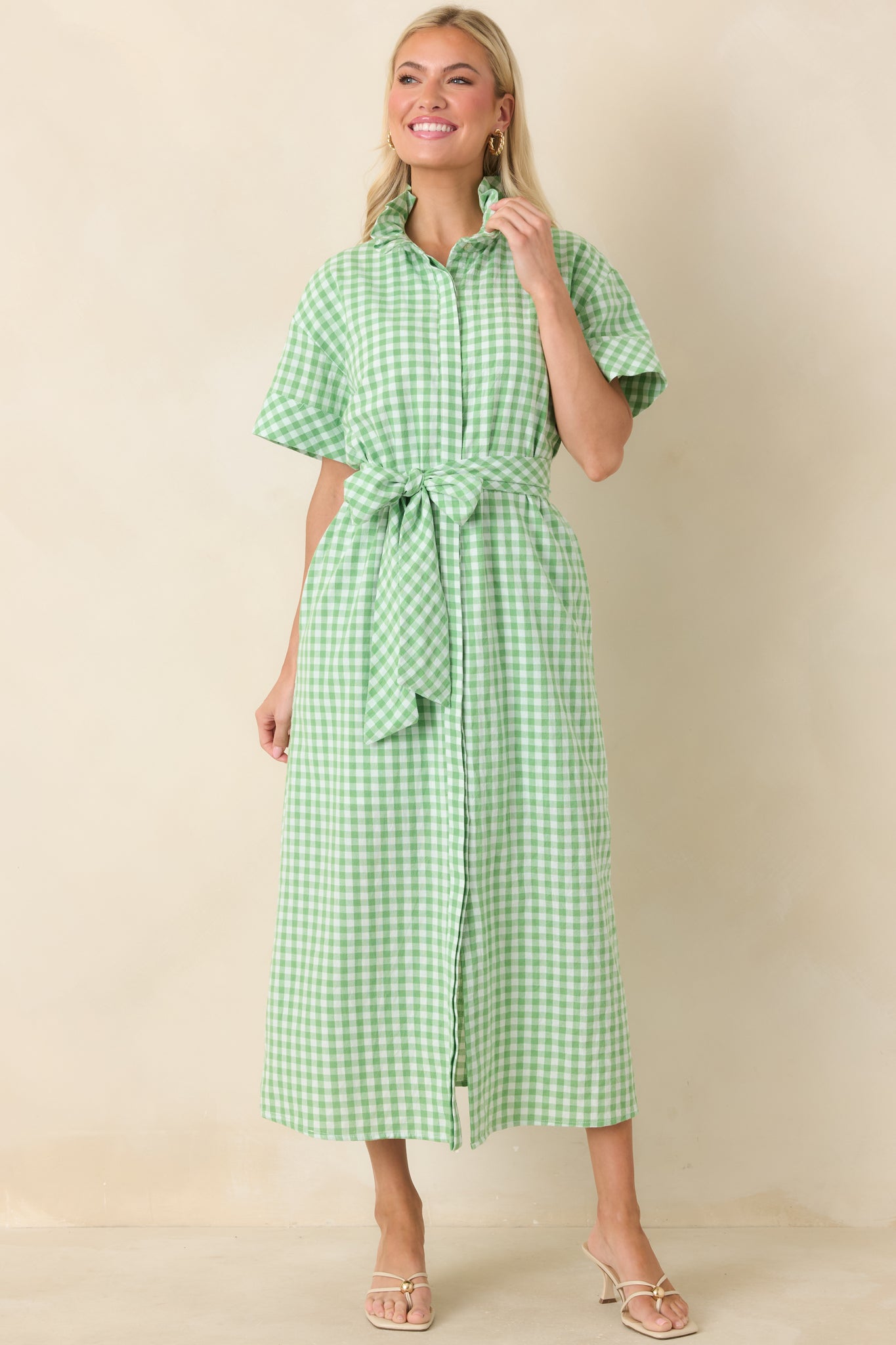 Green and white checked maxi featuring a button-front placket, adjustable waist belt, and full-length skirt for versatile coverage and movement.