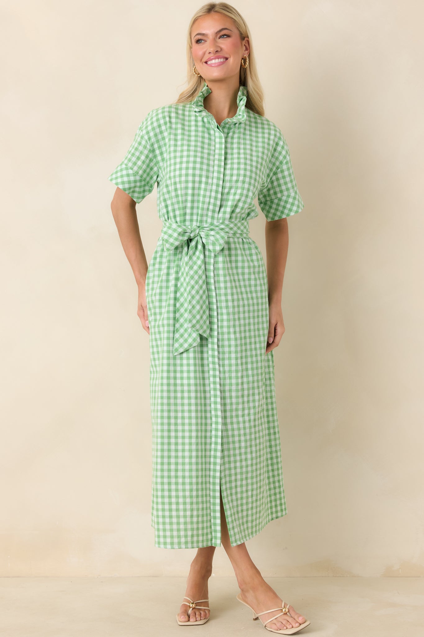 Green and white gingham maxi dress featuring a structured ruffle collar, short sleeves, and a flowing full-length skirt.