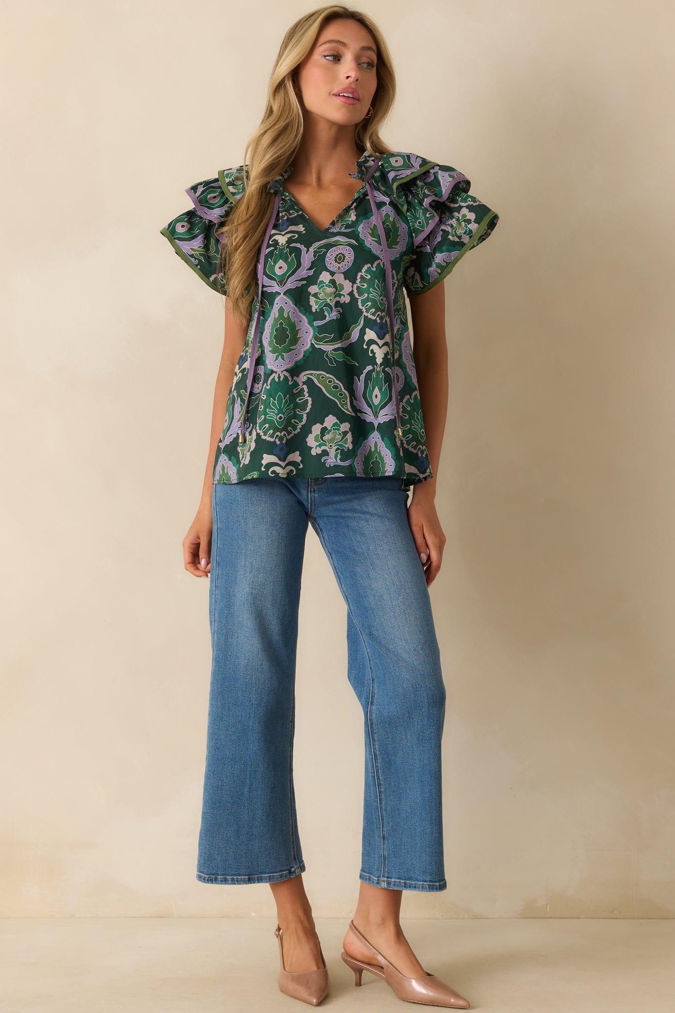 Green blouse highlighting flowing silhouette, multicolor pattern, and delicate ruffle sleeve details.