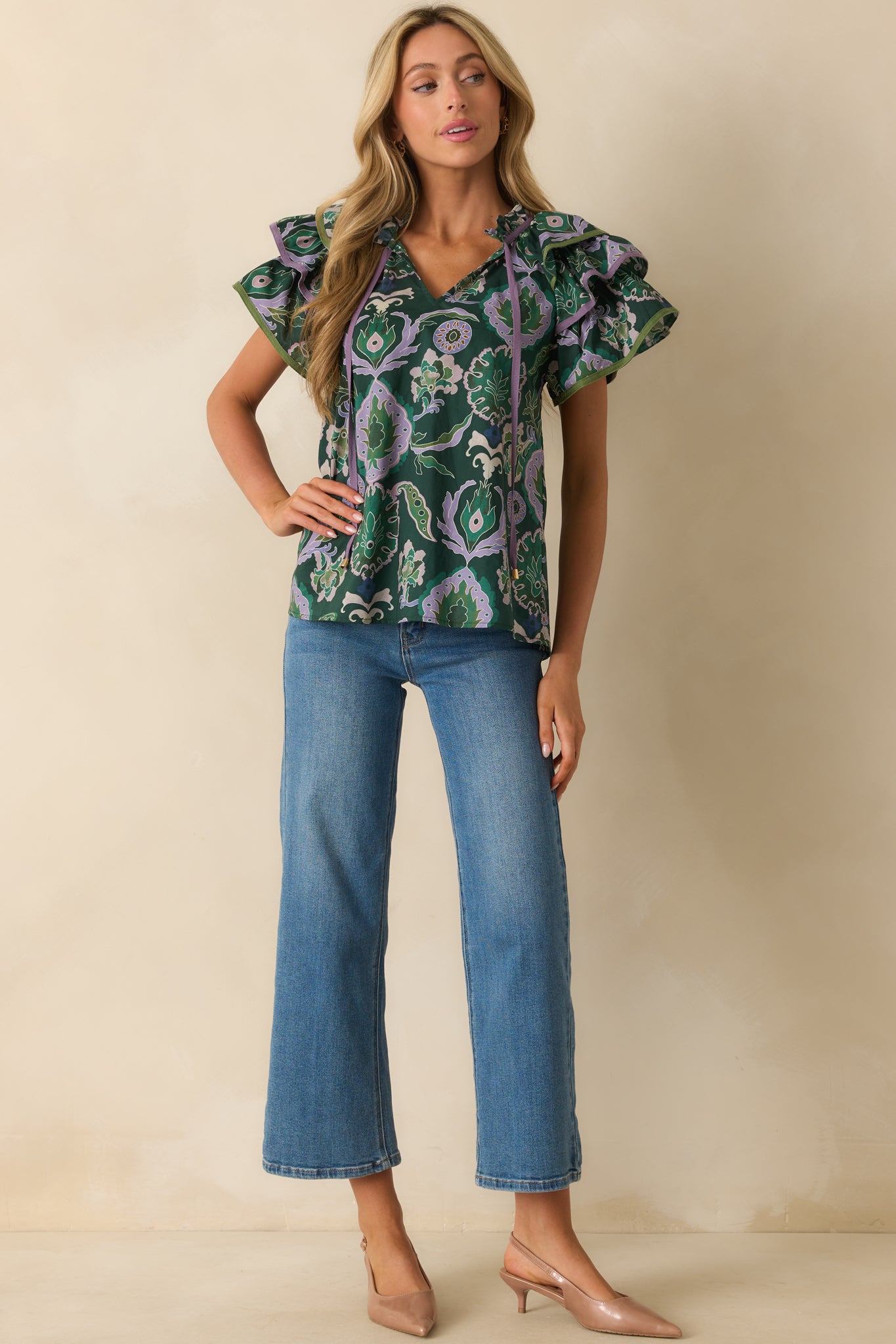 Full-length front view showing relaxed-fit green blouse with ruffled v-neckline and decorative tassels.