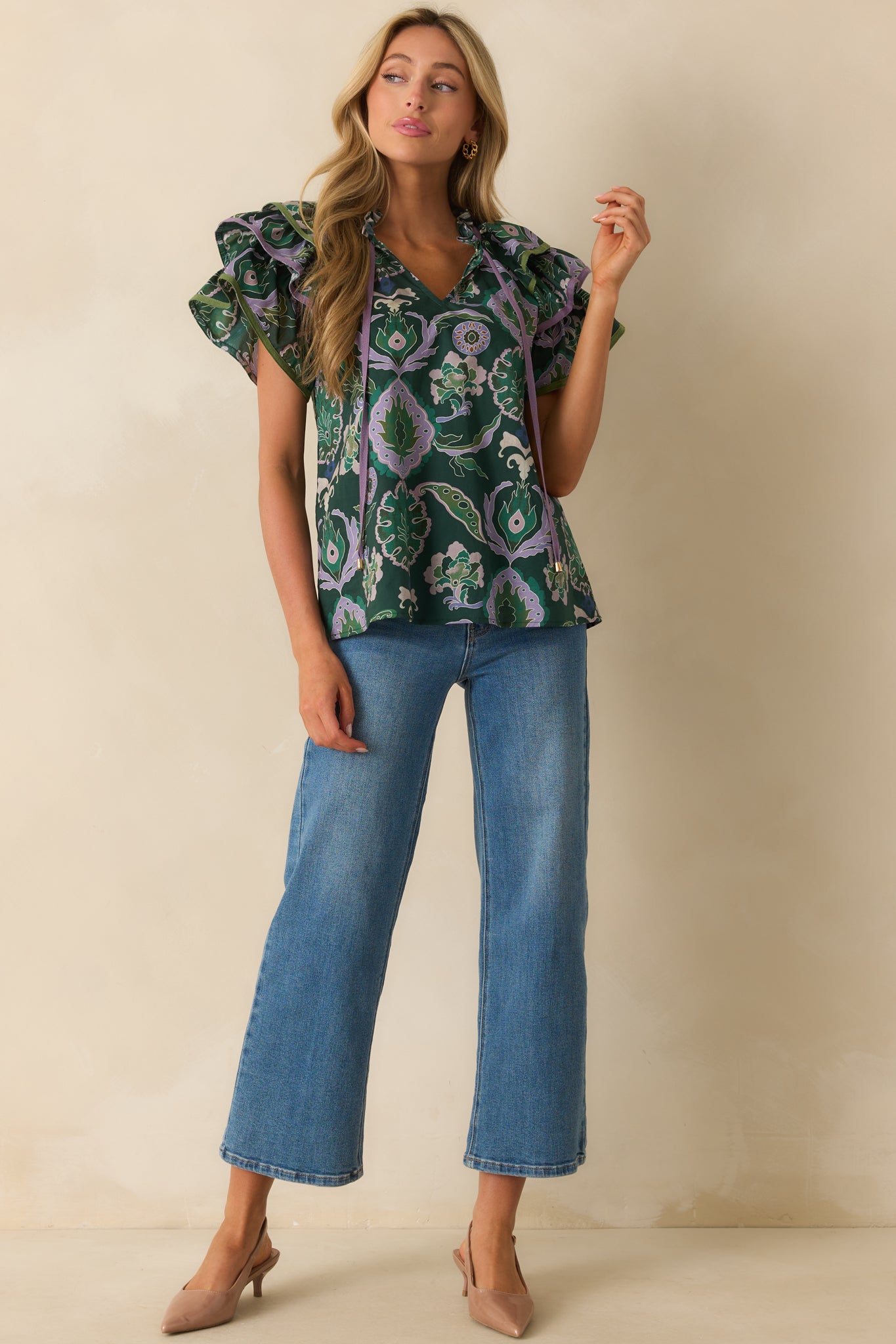 Front view of green blouse featuring short ruffle sleeves and optional self-tie tassels at the neckline.