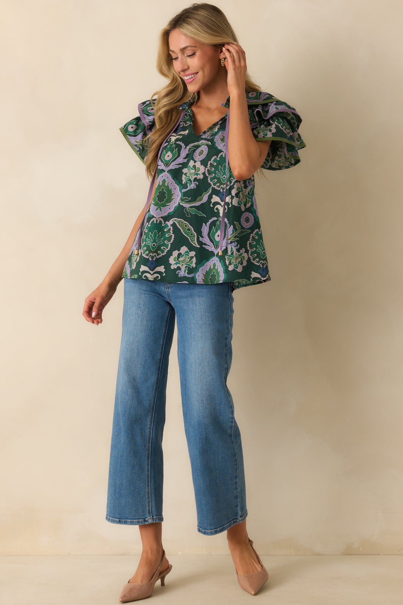 Green blouse with multicolor print, notched v-neckline with ruffle trim, and relaxed fit.