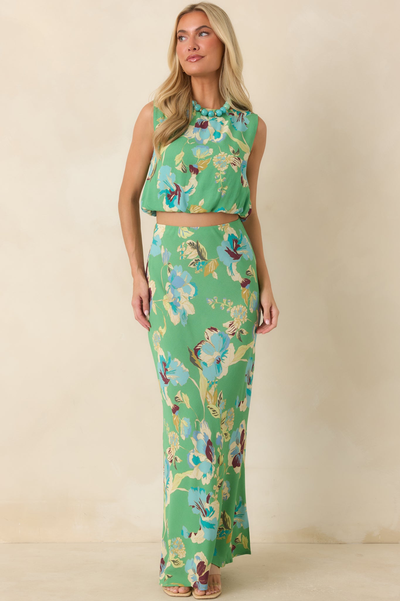 Green floral bias maxi skirt featuring an oversized blue floral print and flowing lightweight silhouette.