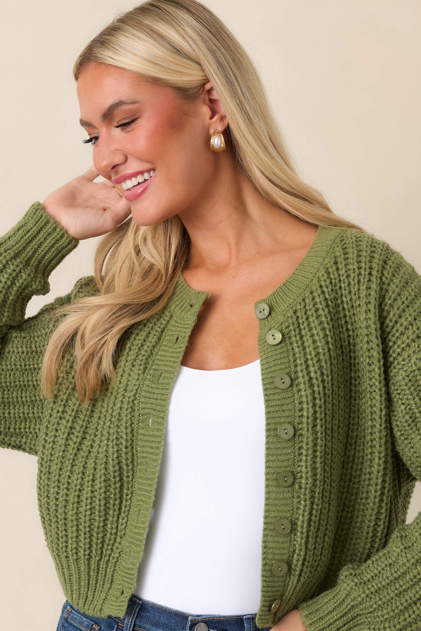 Detailed view of the cardigan's marbled buttons, chunky knit texture, and ribbed trim along the front opening.
