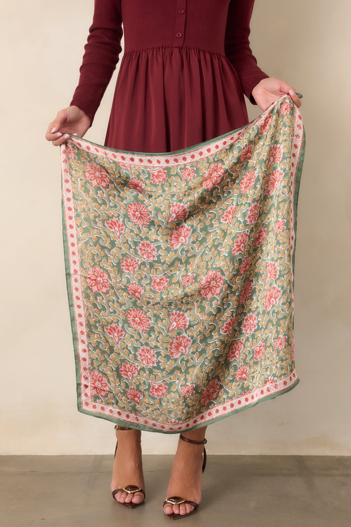 Muted green hair scarf featuring coral and rust florals, golden yellow accents, pale scrolling vines, and a coral and ivory border.
