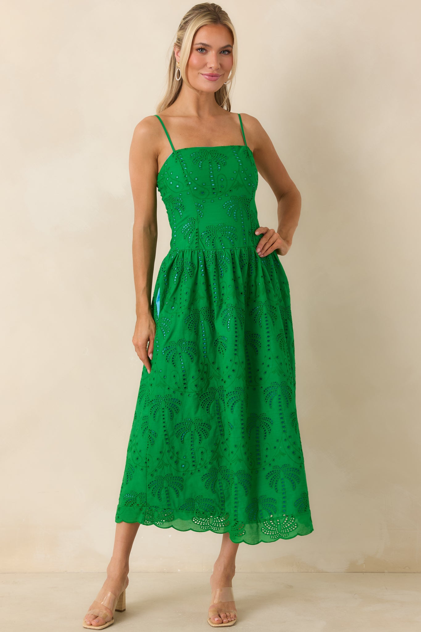 Green cotton eyelet midi dress with fitted bodice, flowing skirt, and adjustable straps.