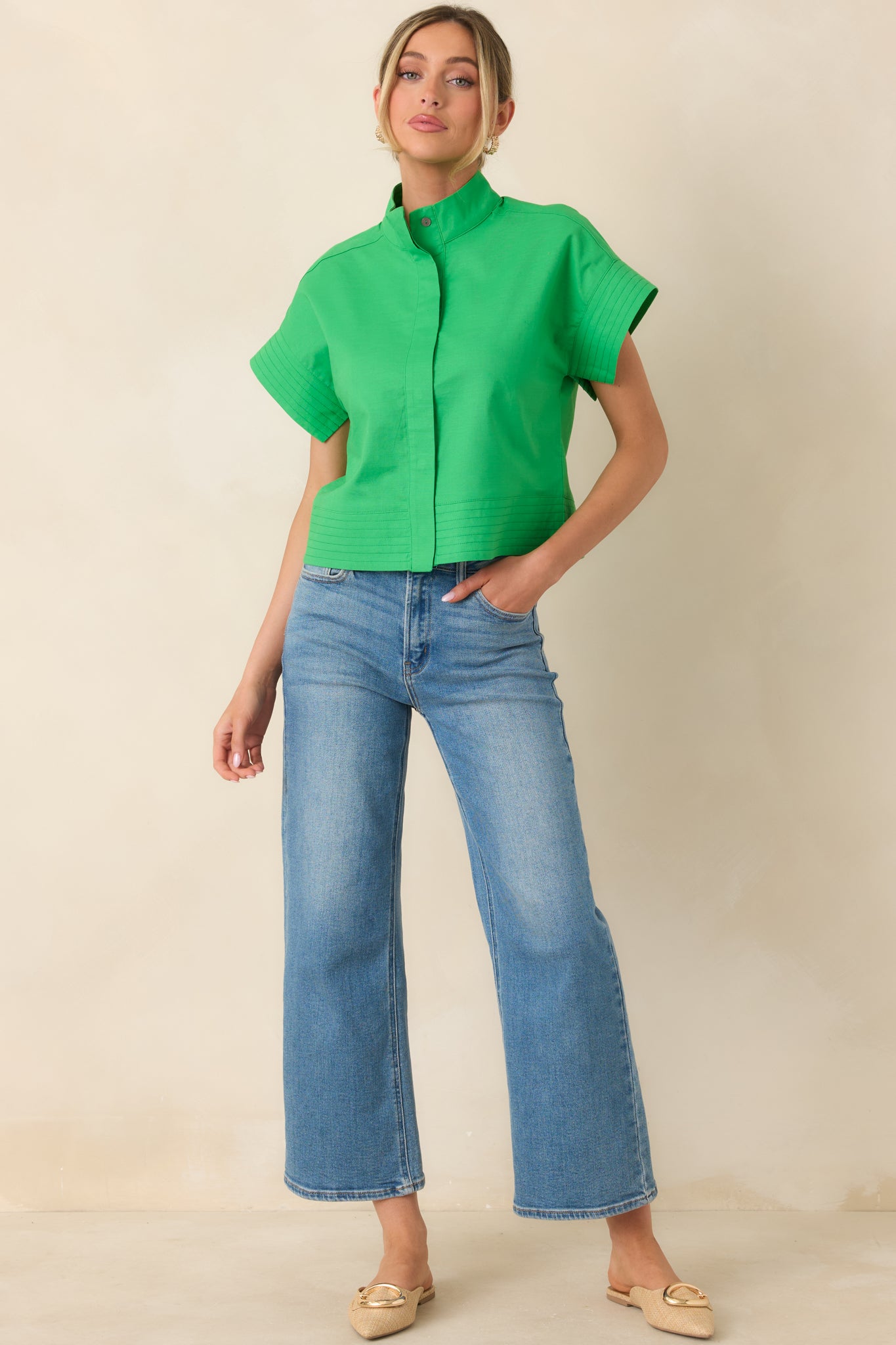 Front view of a green cotton-linen top with structured shape, polished neckline, and relaxed boxy fit.