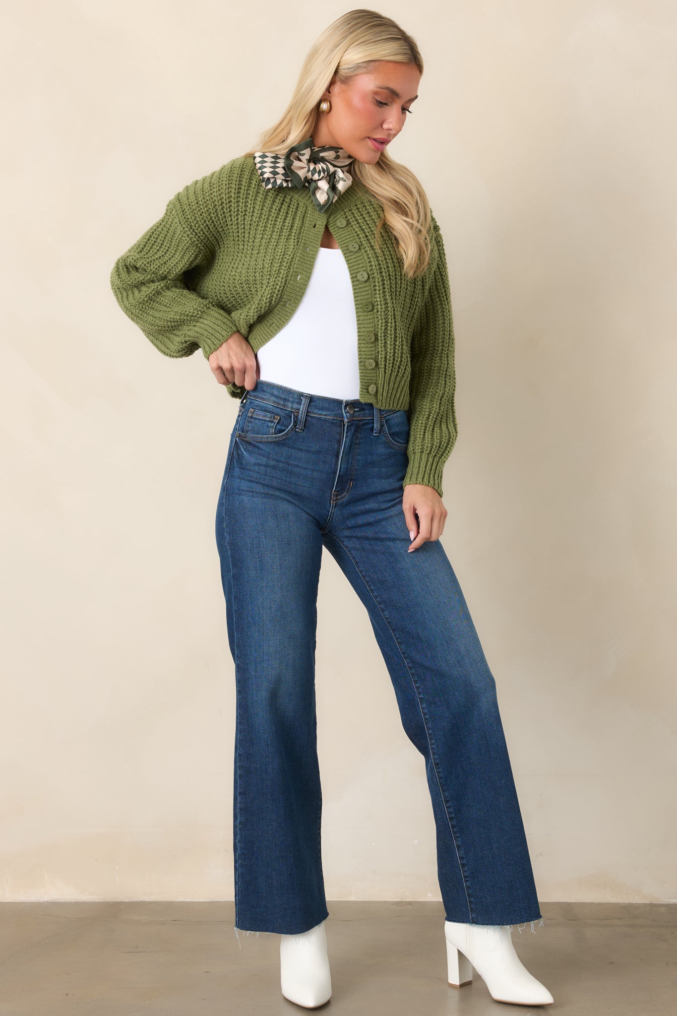 Cropped green cardigan designed with textured cable-style stitching, tonal buttons, ribbed edges, and a classic crew neckline.