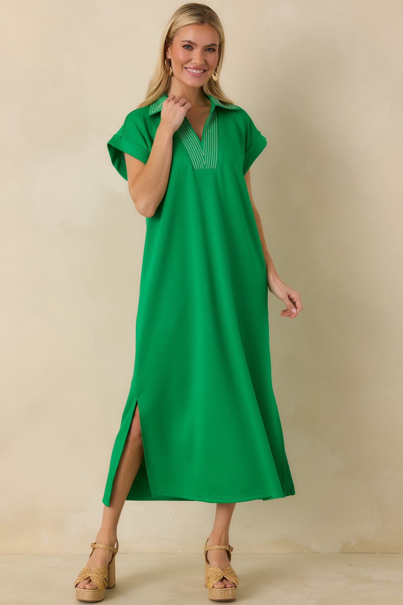 Midi-length green knit dress showcasing contrast stitching at the neckline and easy drape.