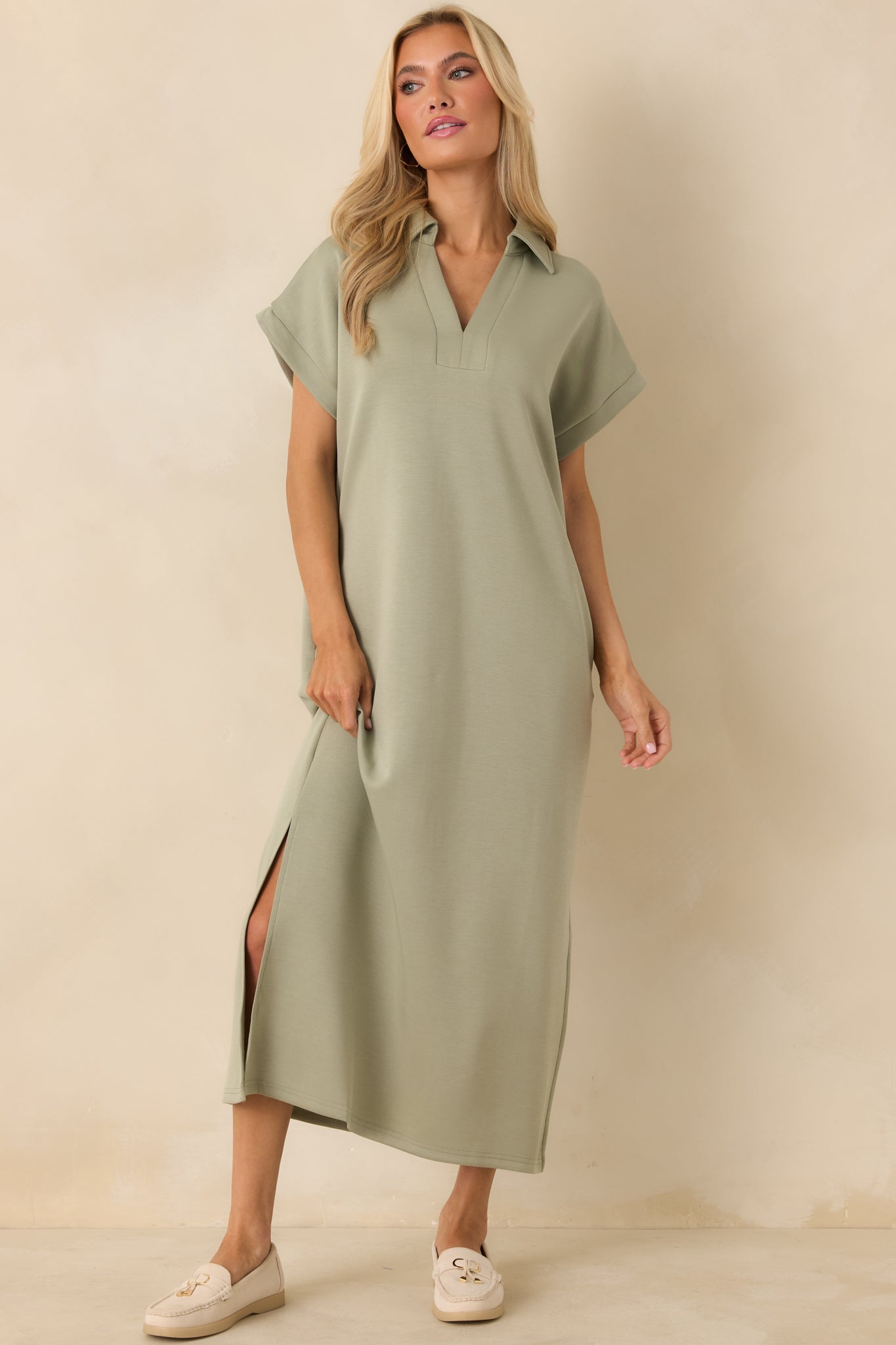 Sage green dress cut at midi length with short sleeves, side vent leg slits, and hidden seam pockets for everyday ease.