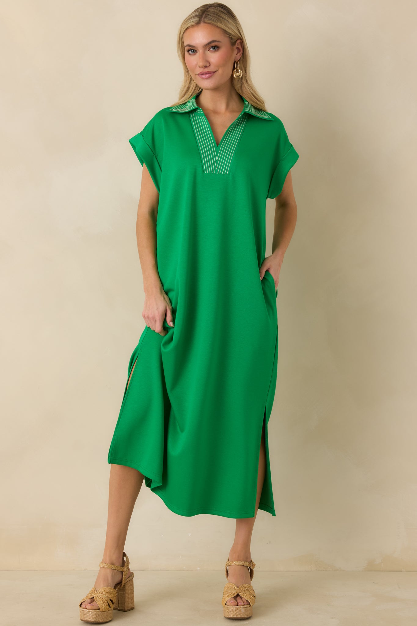 Green knit dress with straight fit, V-neck detail, and midi-length hemline.