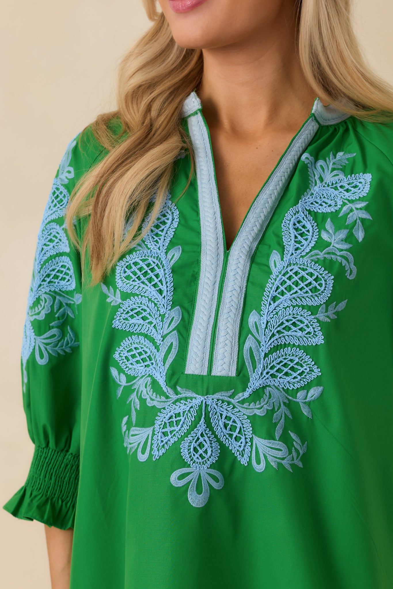 Close-up of the green embroidered top highlighting intricate stitching and contrast neckline trim.