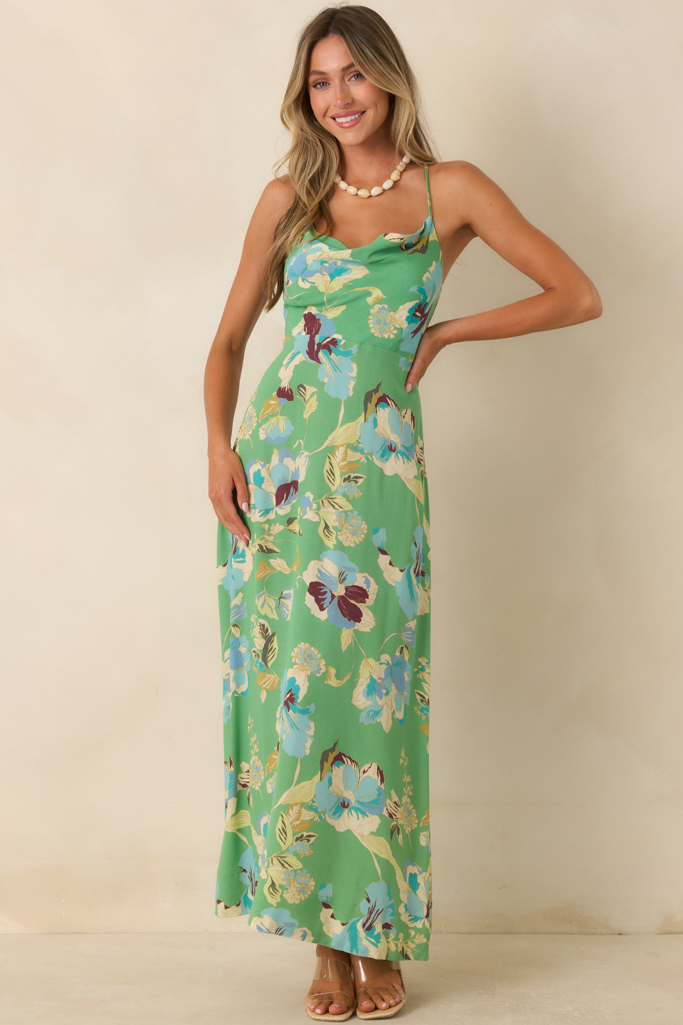 Green floral maxi dress featuring a draped cowl neckline, spaghetti straps, and a flowing fit-and-flare silhouette.