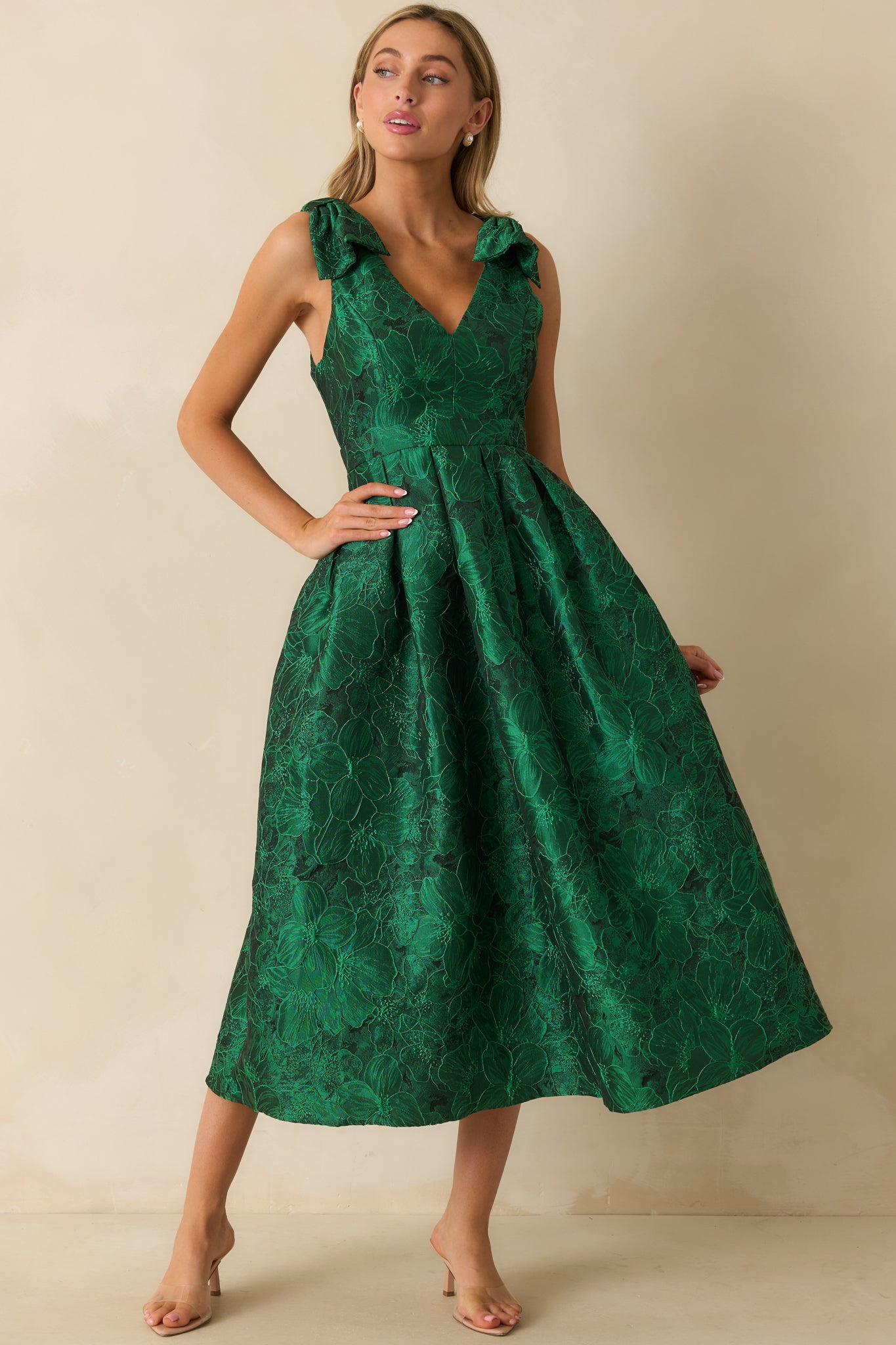 Front-facing green floral dress with functional side pockets, bow-tied straps, and subtle floral print.