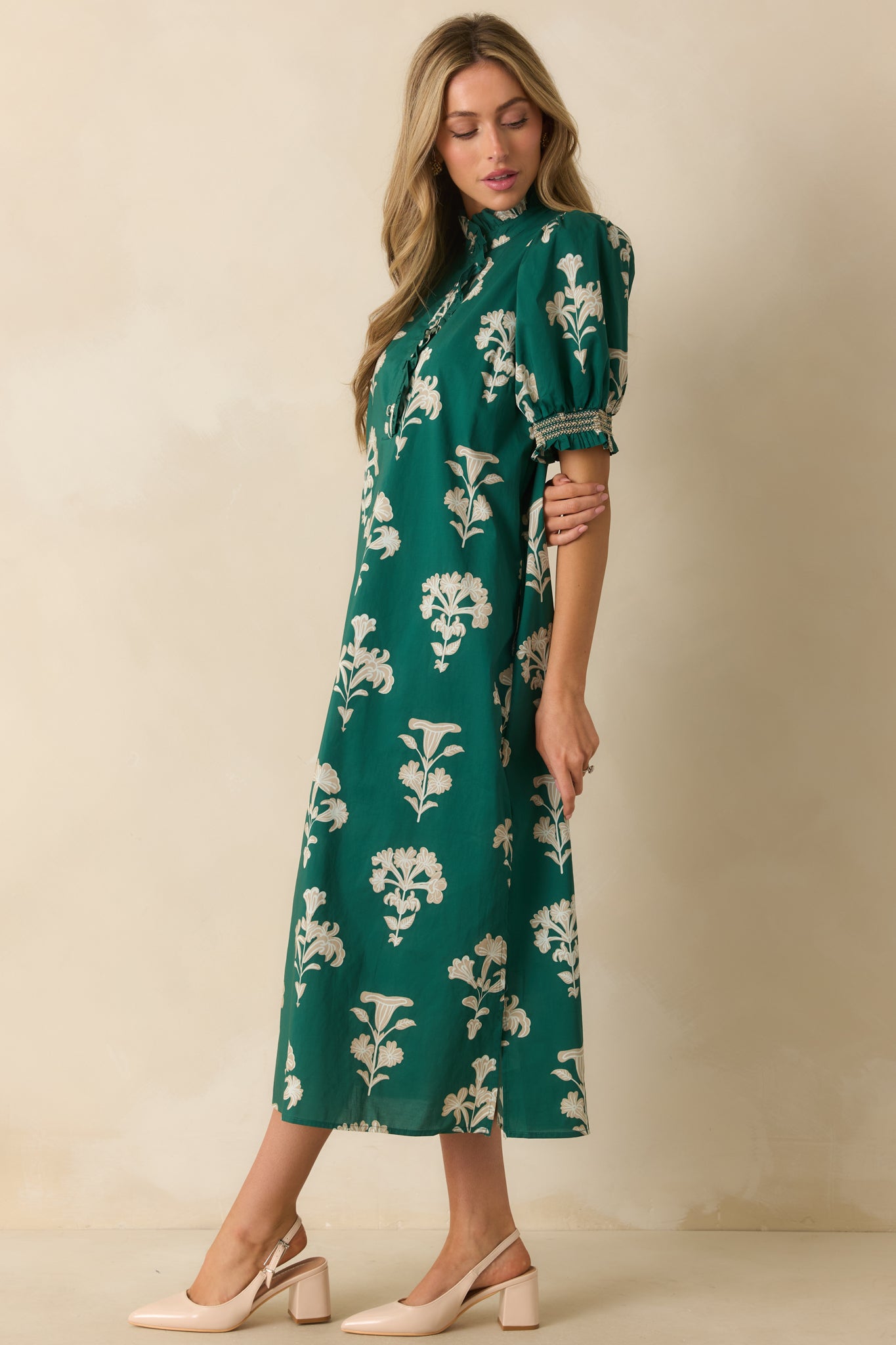 Maxi-length green dress patterned with ivory florals and finished with smocked cuffs and a breezy silhouette.