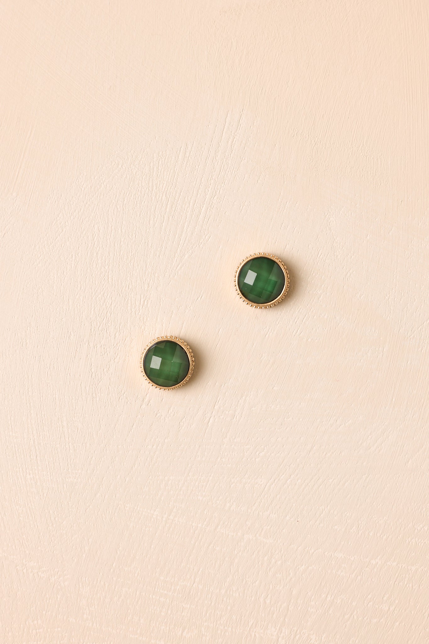 Green gemstone stud earrings showcasing faceted stones, delicate gold settings, and a refined vintage-inspired design.