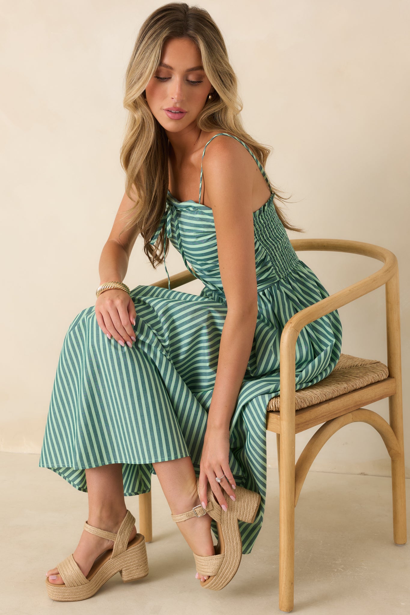 Close view of the green and ivory striped maxi dress highlighting the gathered waist, crisp stripe pattern, and smooth cotton construction.