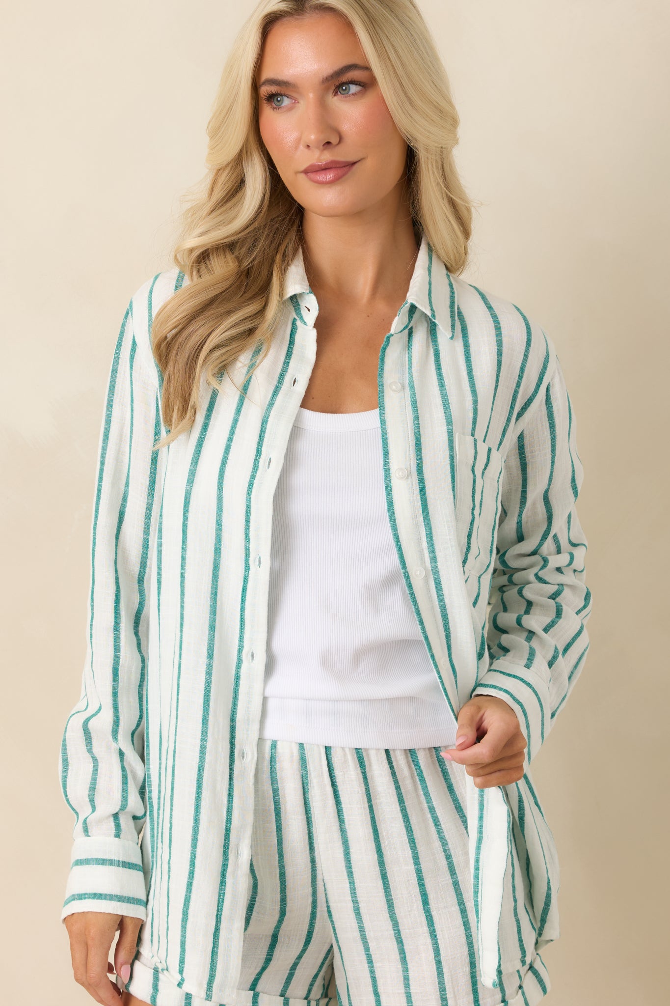 Detailed look at the button-front design, soft textured finish, and green and ivory woven stripes of the top.