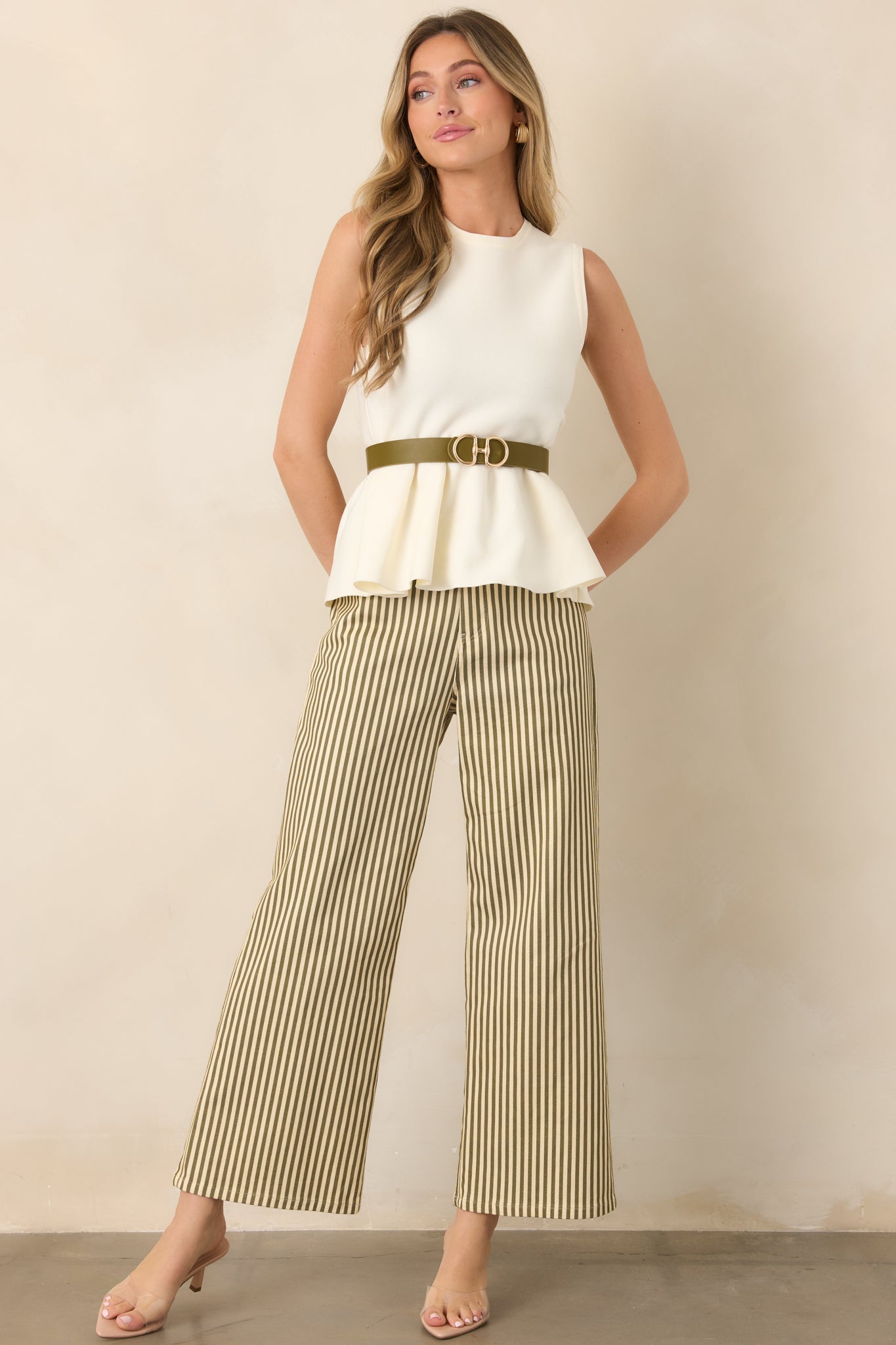 Green and ivory vertically striped pants featuring a relaxed wide-leg silhouette, belt loops, zip fly, button closure, and functional pockets.