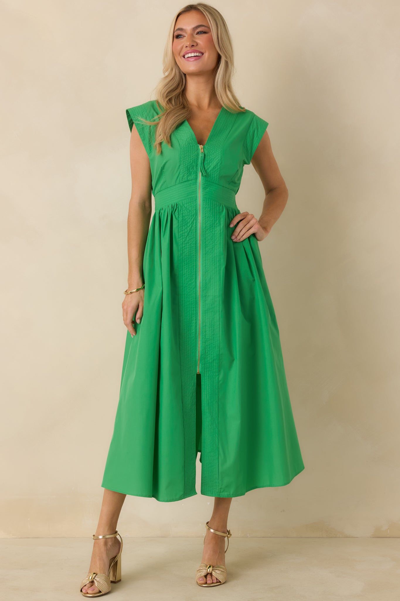 Green midi dress shown from the front, emphasizing the lightly gathered skirt and defined waistline.