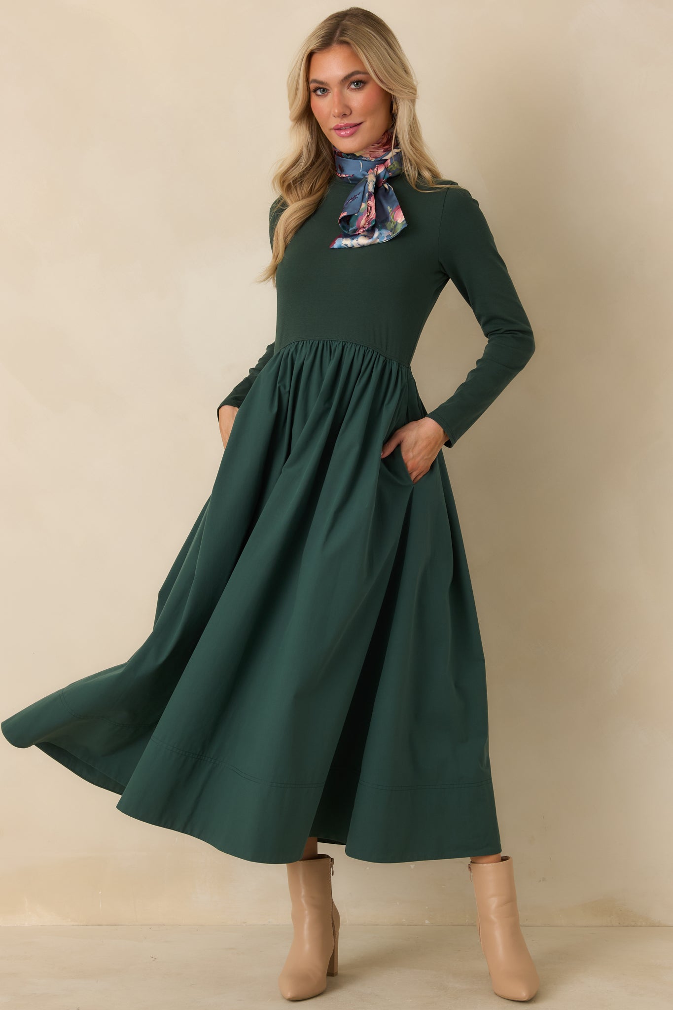 Green mixed-media dress showcasing discreet side pockets, a fitted long sleeve top, and a sweeping gathered midi skirt.