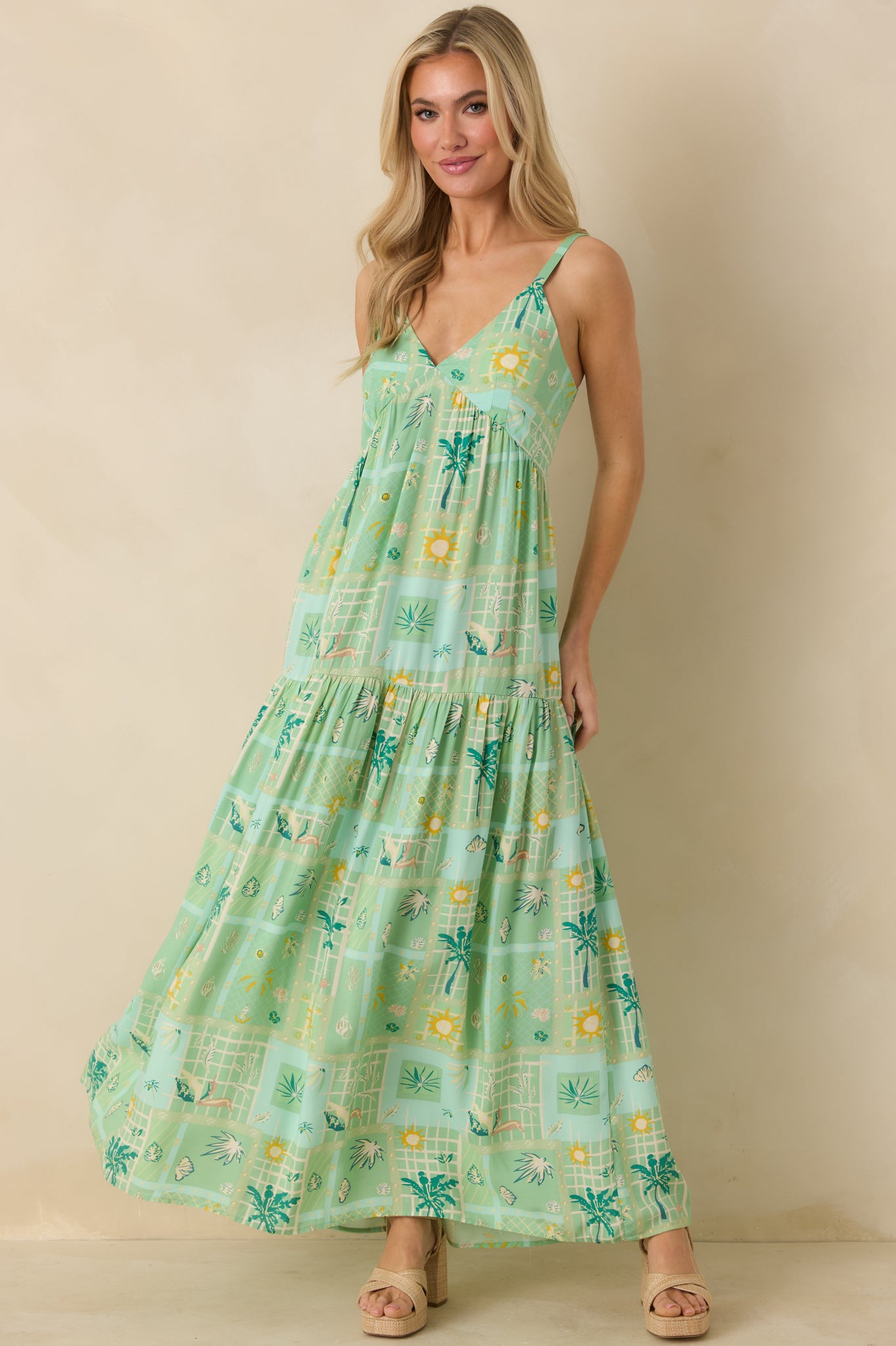 Green multicolor maxi dress with V-neckline, adjustable straps, empire waist, and tiered full-length skirt.