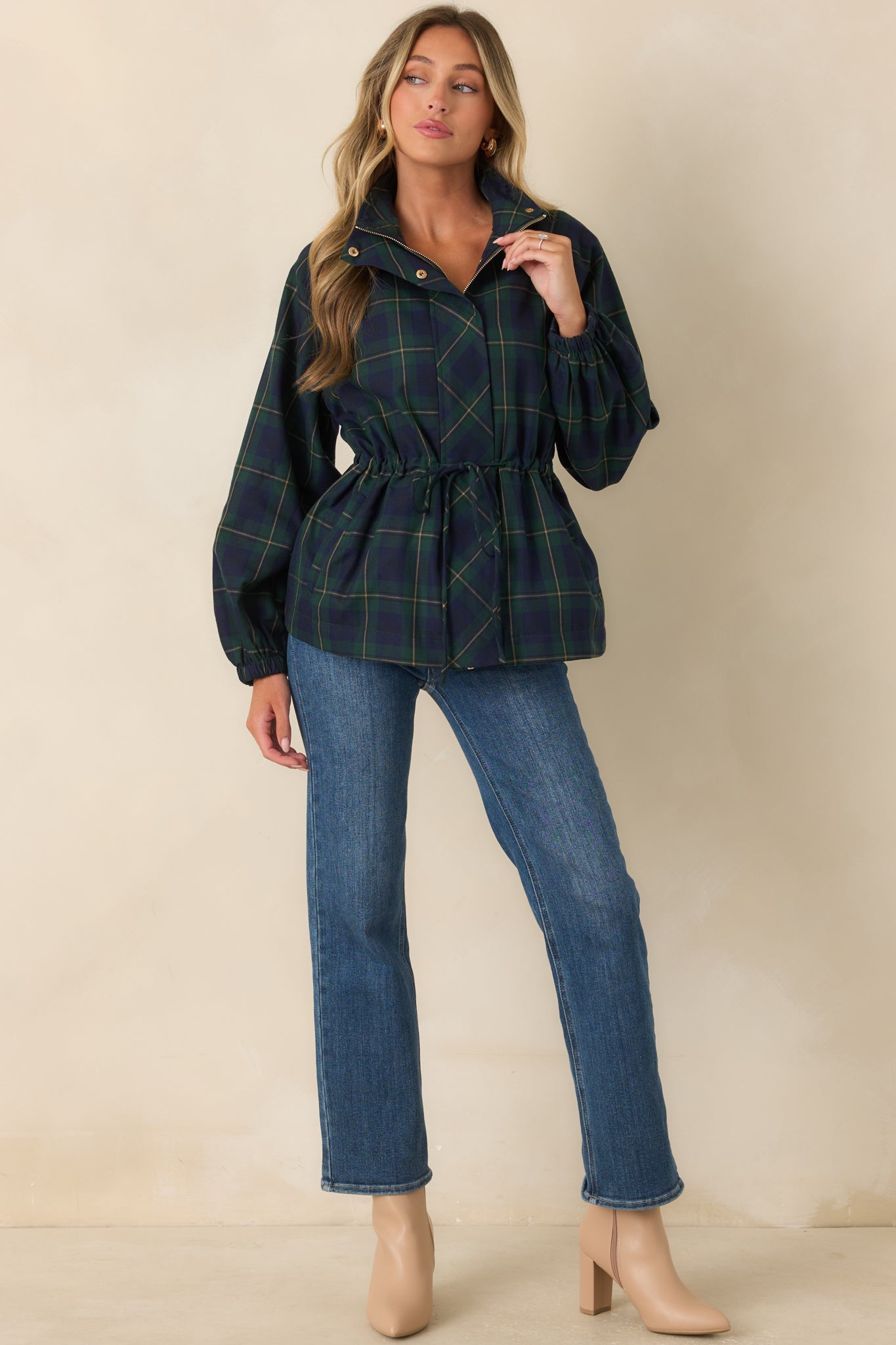 Green and navy plaid jacket showcasing a relaxed utility-inspired silhouette, long sleeves, oversized front patch pockets, and defined drawstring waist.