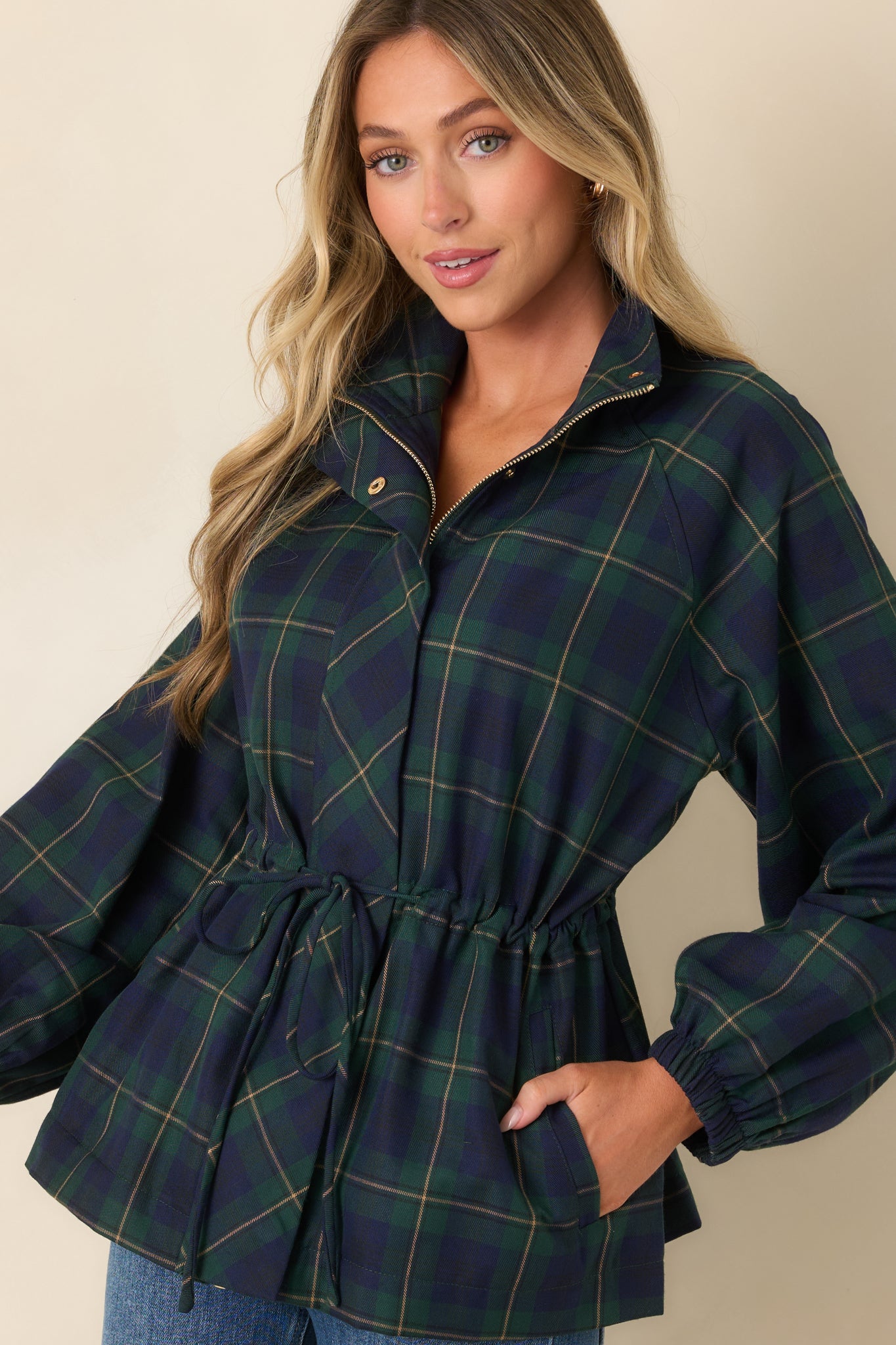 Detailed view of the jacket showcasing the structured collar, front zipper, snap closure, and distinctive green and navy plaid pattern.