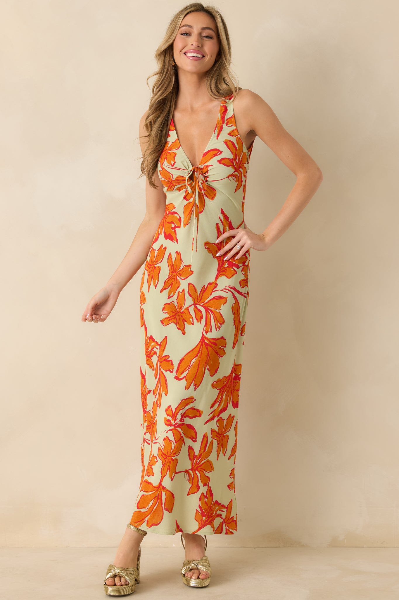 Green and orange floral maxi dress showing its V-neckline and airy drape.