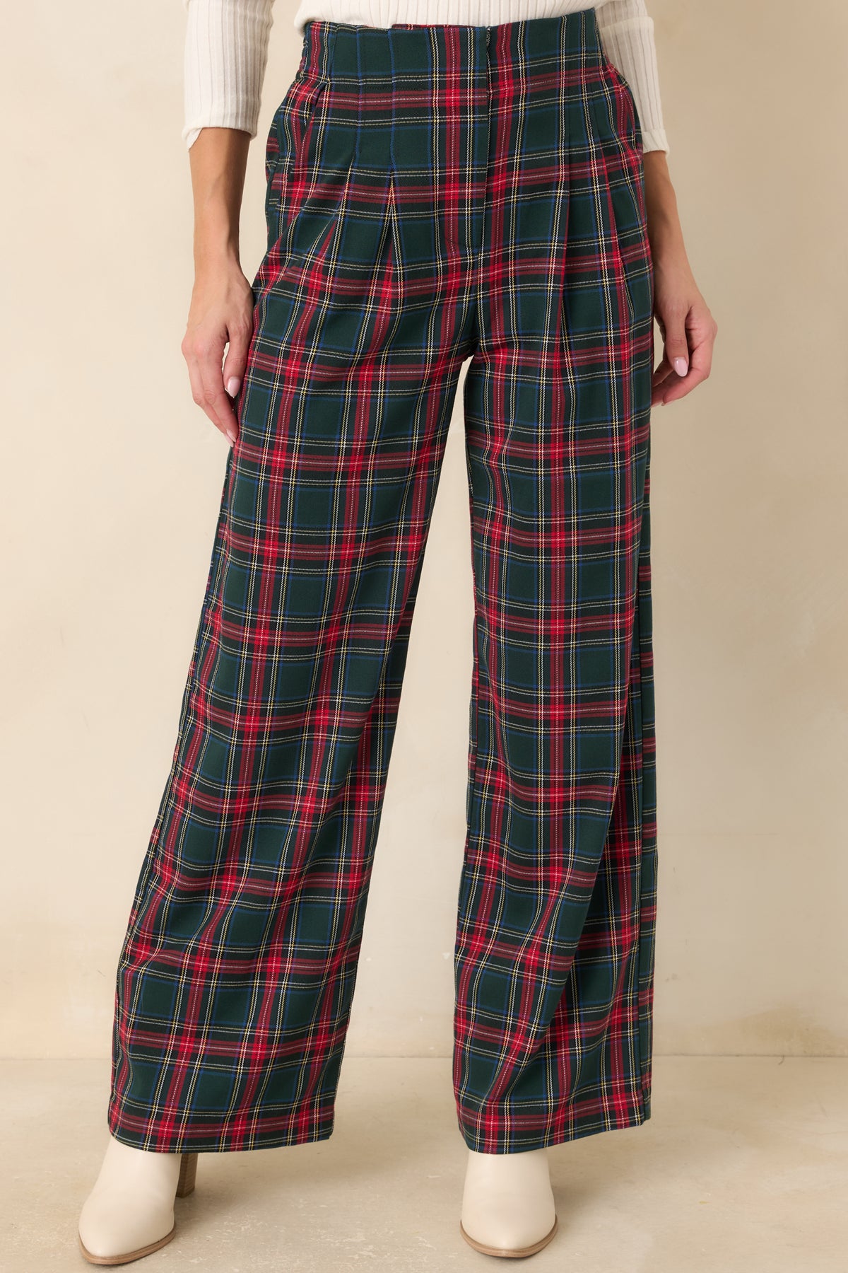 Green plaid trousers with front pleats that create a polished shape through the hips and wide legs.