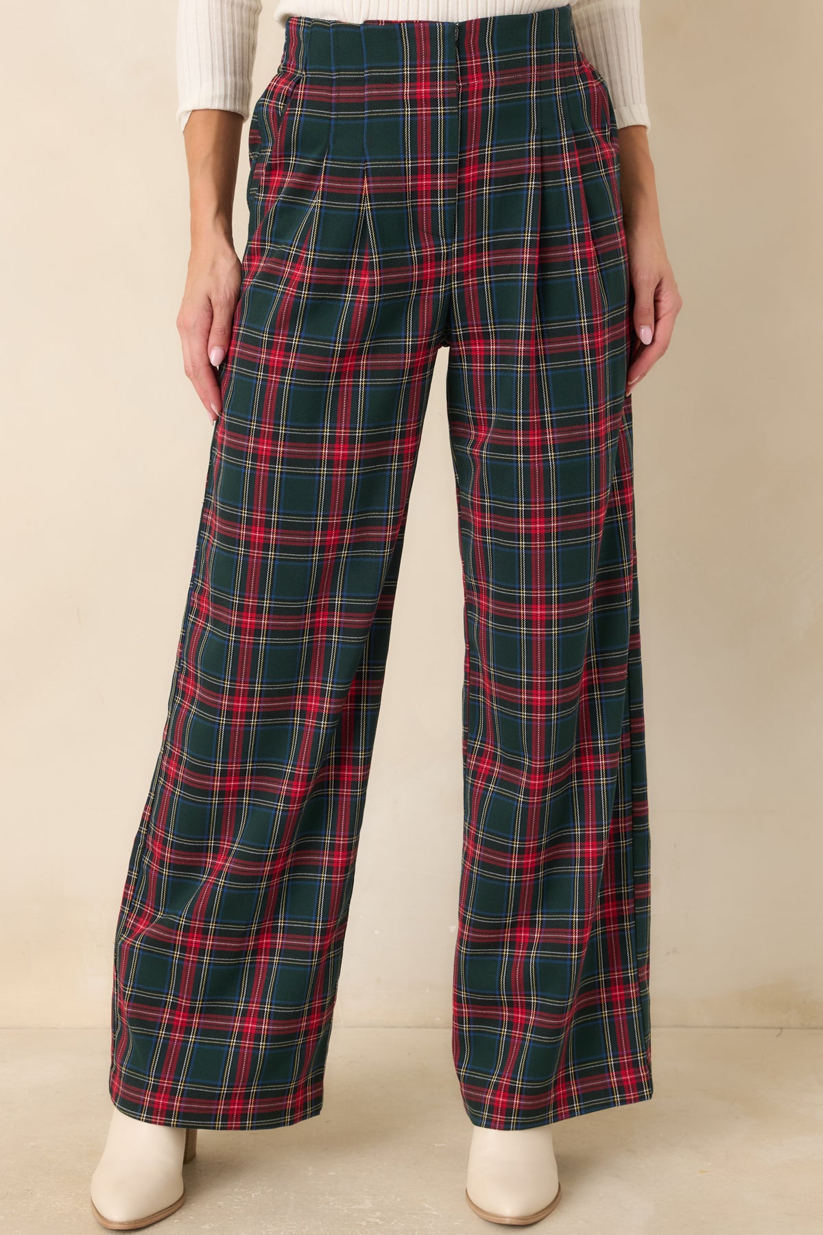 Green plaid pants showcasing the high-rise waist, front pleats, and tailored upper silhouette.
