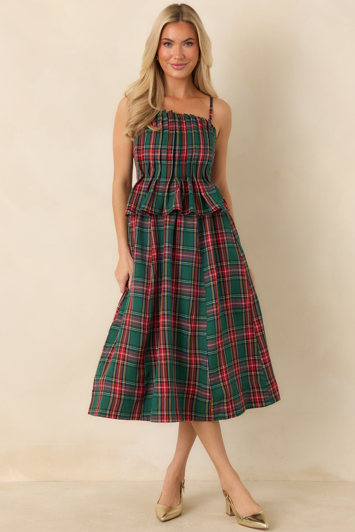 Green plaid midi dress featuring a ruffled neckline, adjustable shoulder straps, and a gently flared skirt.