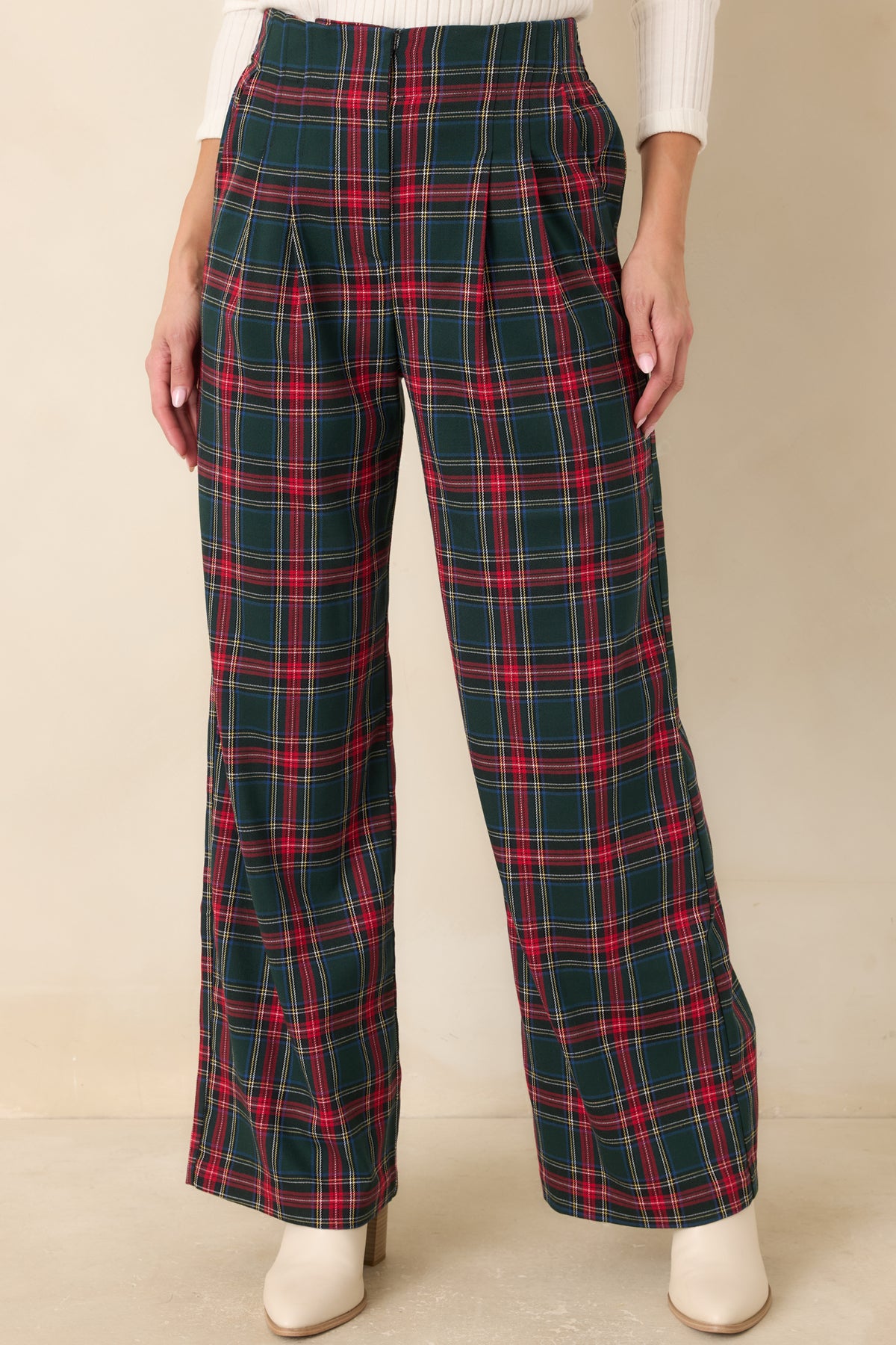 Wide-leg green plaid trousers featuring functional side pockets and crisp pleating below the waistband.
