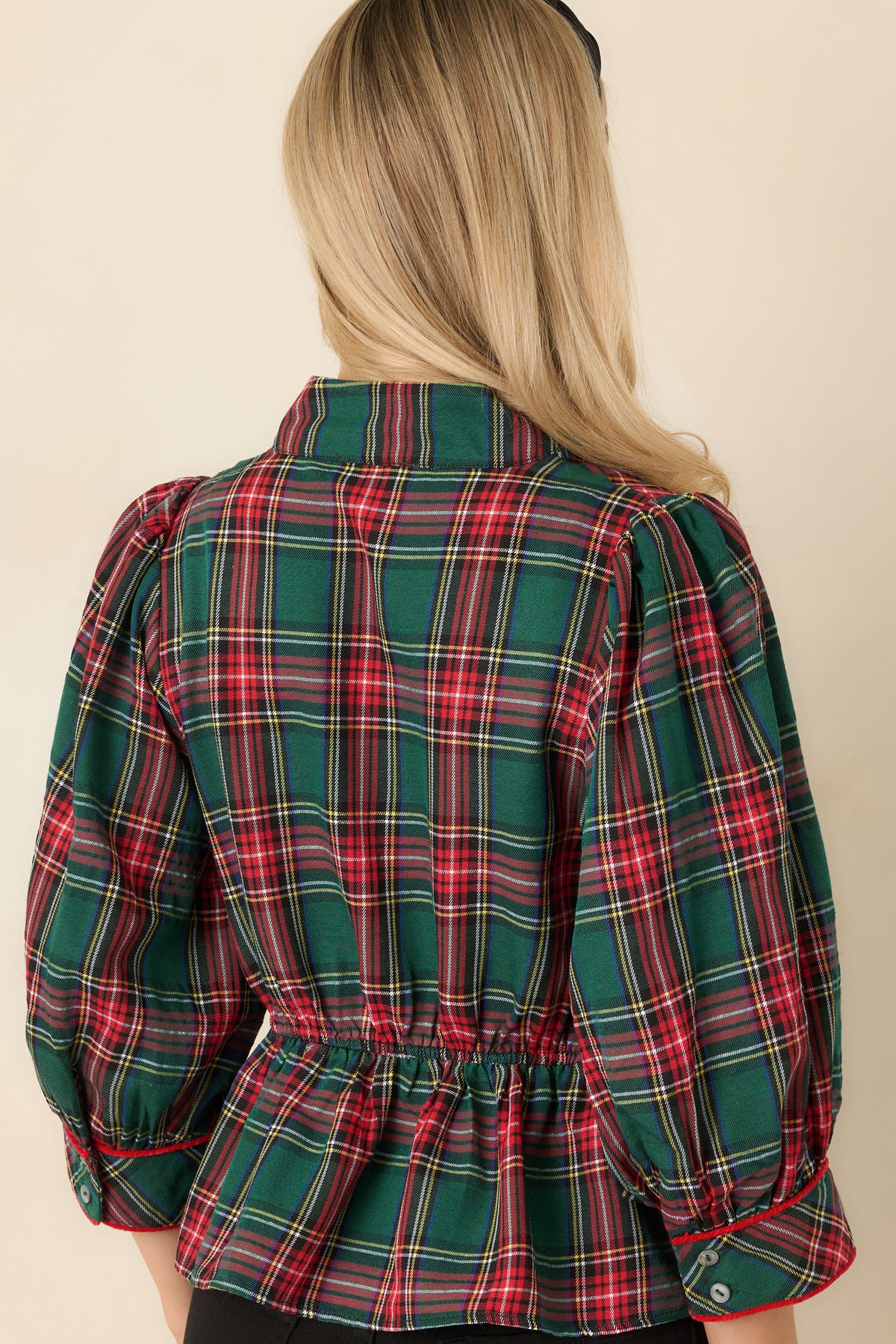 Rear view of the green and red plaid top showing the elasticized back waist and gathered peplum hem.