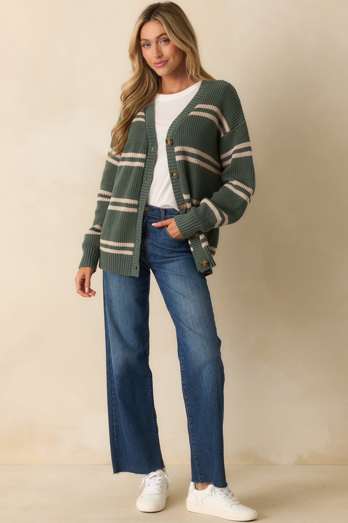 Green ribbed knit cardigan with horizontal beige stripes, V-neckline, and functional button front closure.