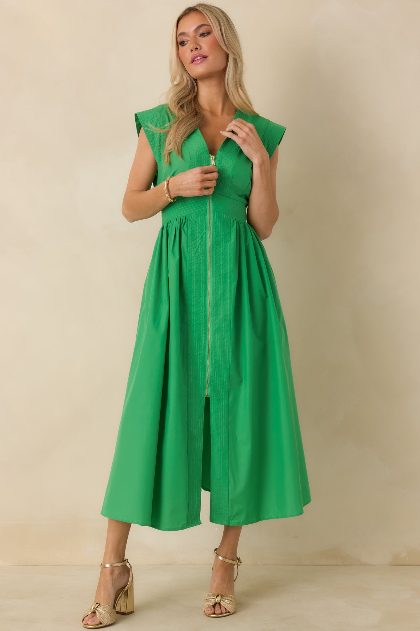 Front angle of green sleeveless midi dress showcasing the gold zipper detail and tailored bodice.