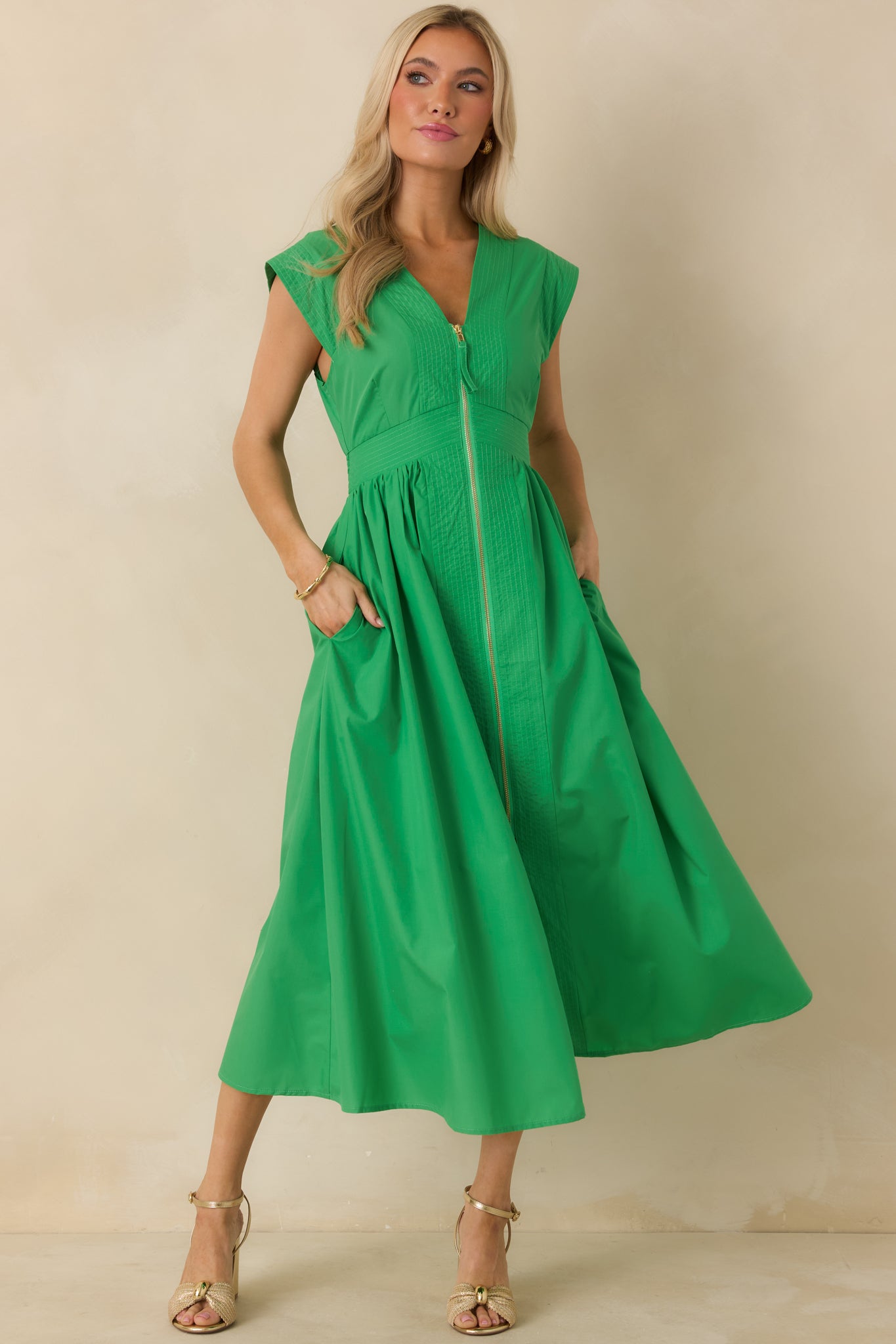 Green sleeveless midi dress featuring a V-neckline, gold-tone front zipper, and fitted waist.