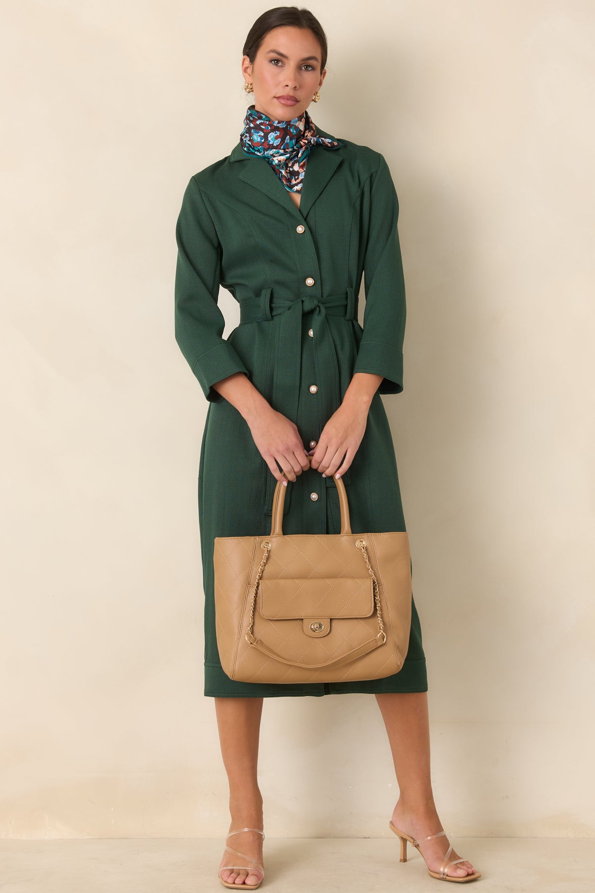 Tailored green dress with vertical seams defining the bodice and straight midi skirt.