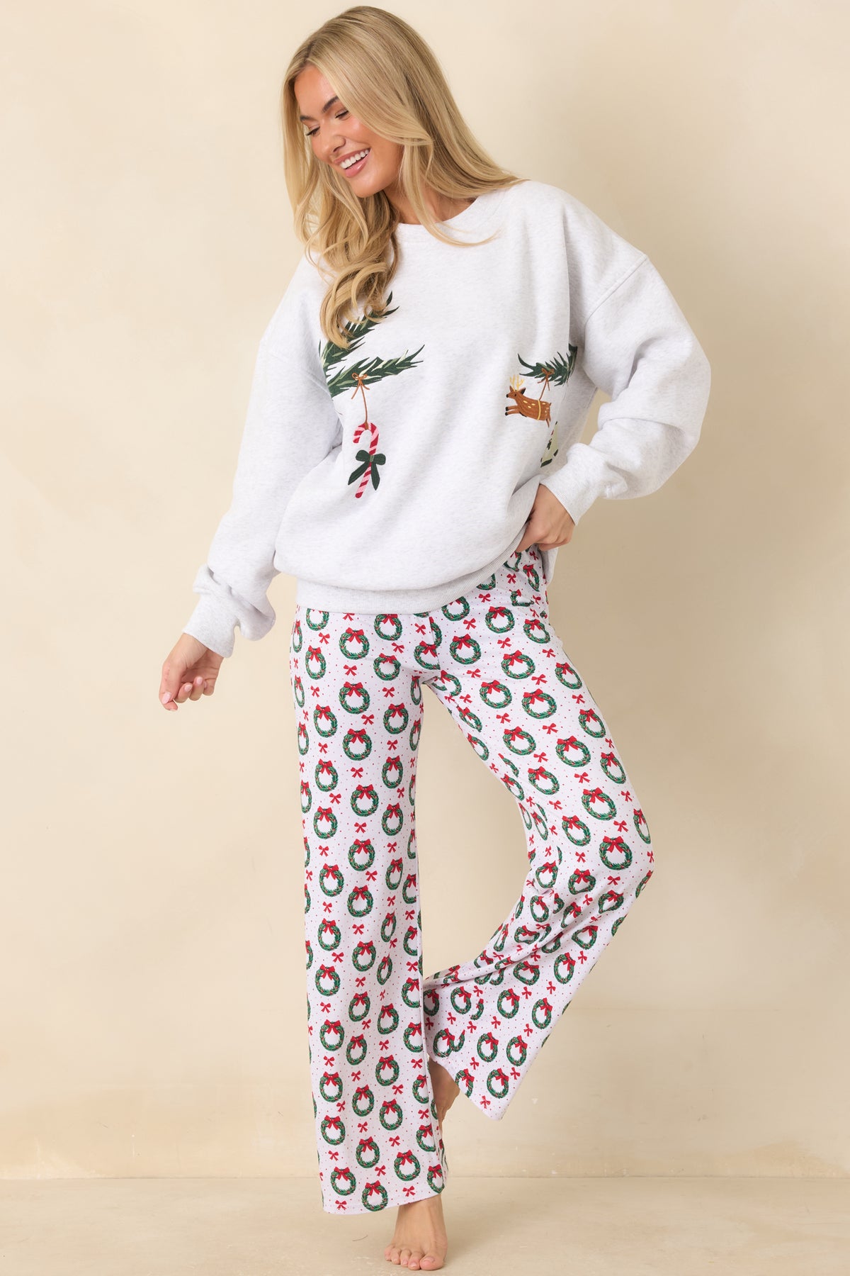 Relaxed grey sweatshirt with festive embroidery featuring a cocktail glass, candy cane, reindeer, and tiny holiday sweater.
