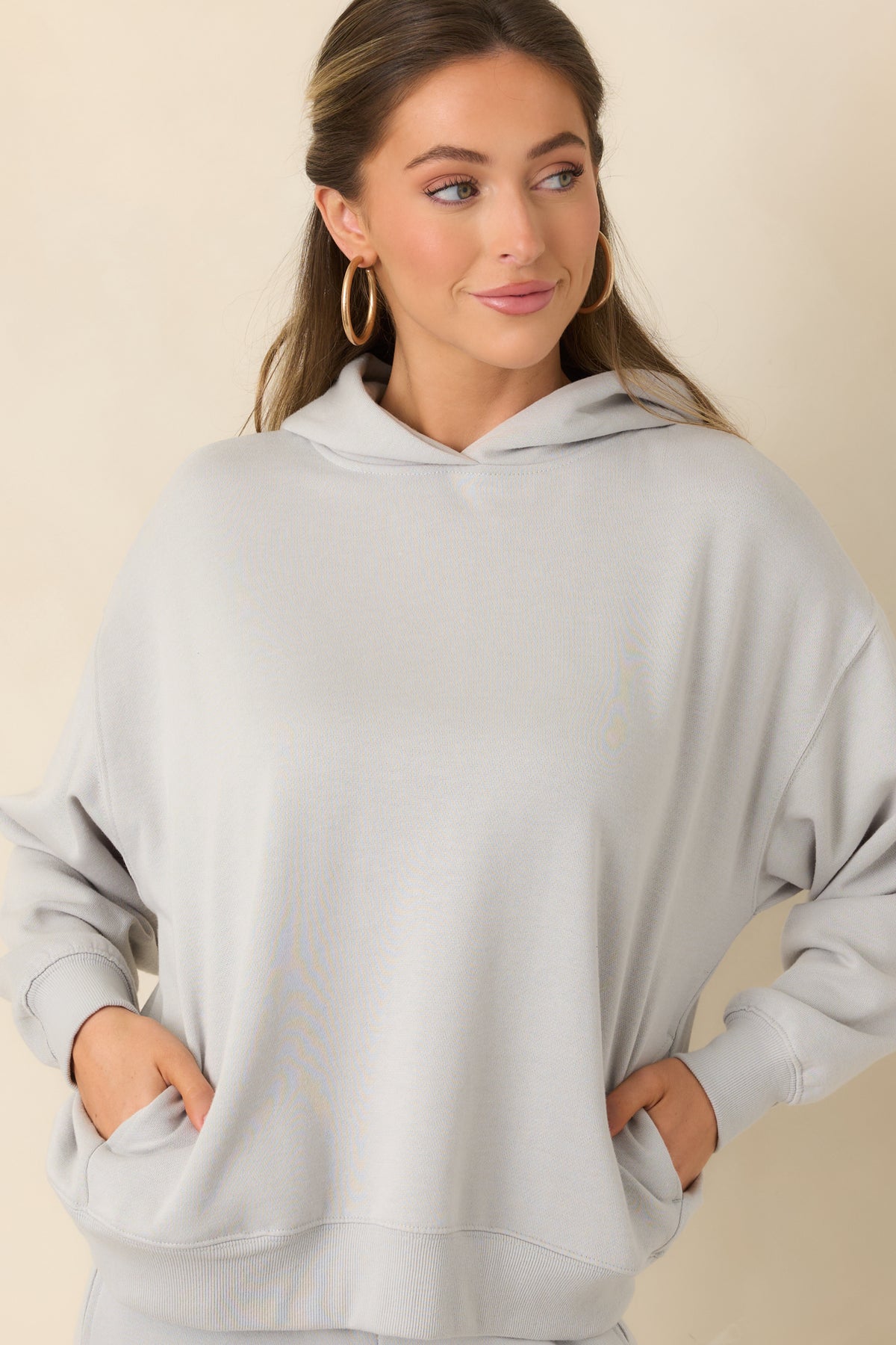 Soft grey hoodie with a ribbed bottom hem that adds structure to its relaxed shape.