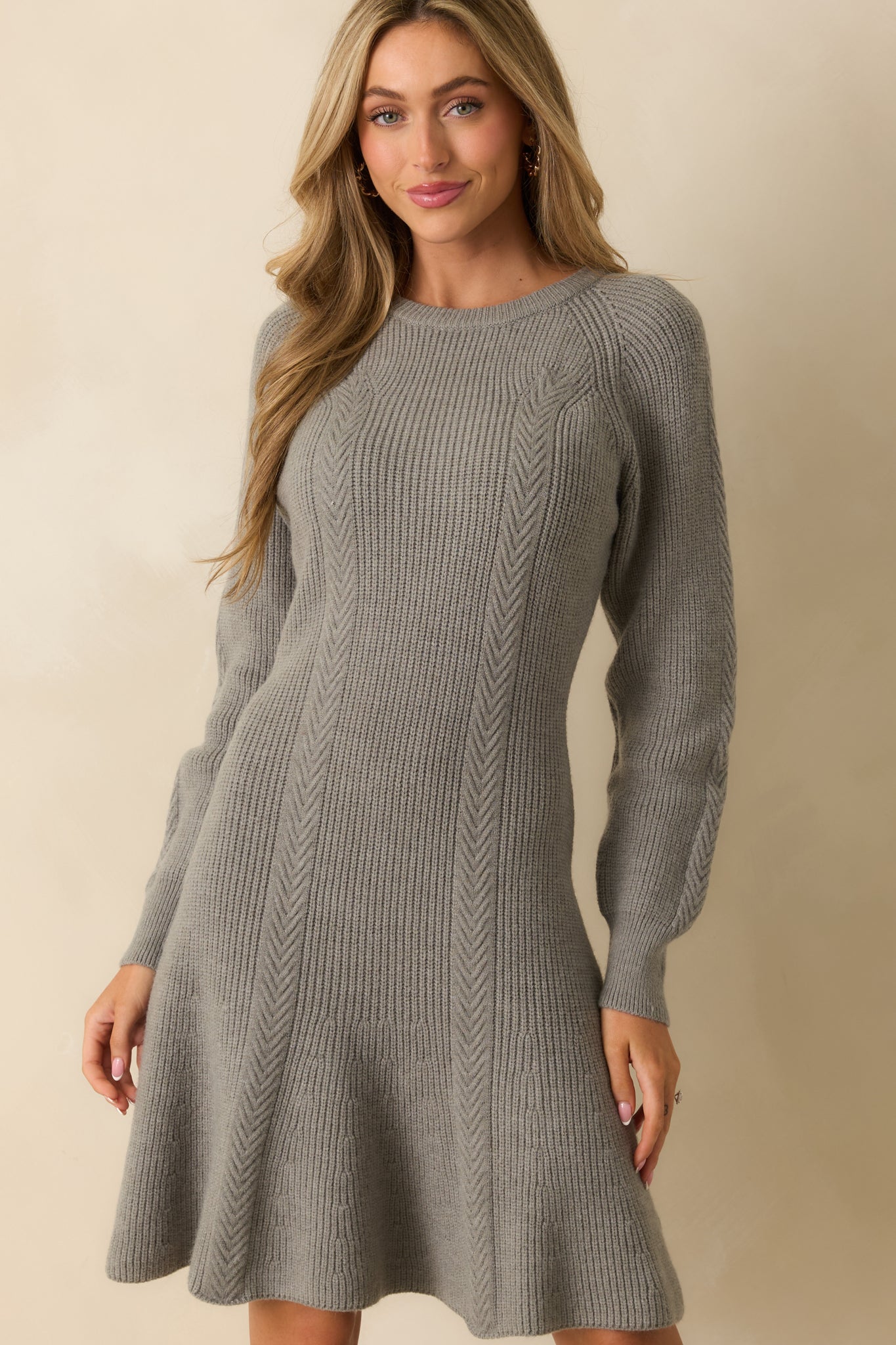 Focus on flared hem and knit pattern of grey ribbed sweater dress.